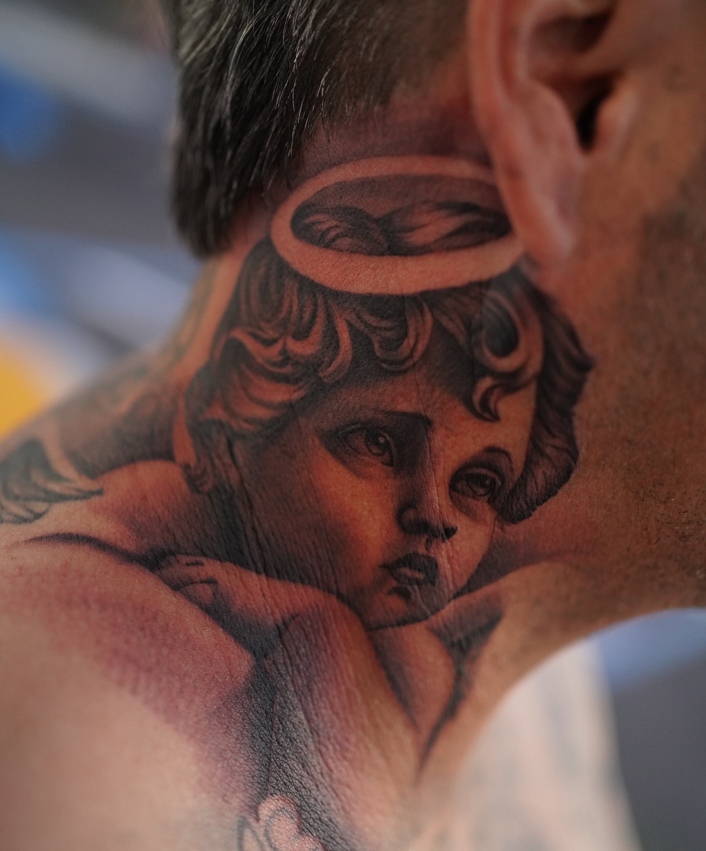 Cherub realism tattoo on the neck by tombstone