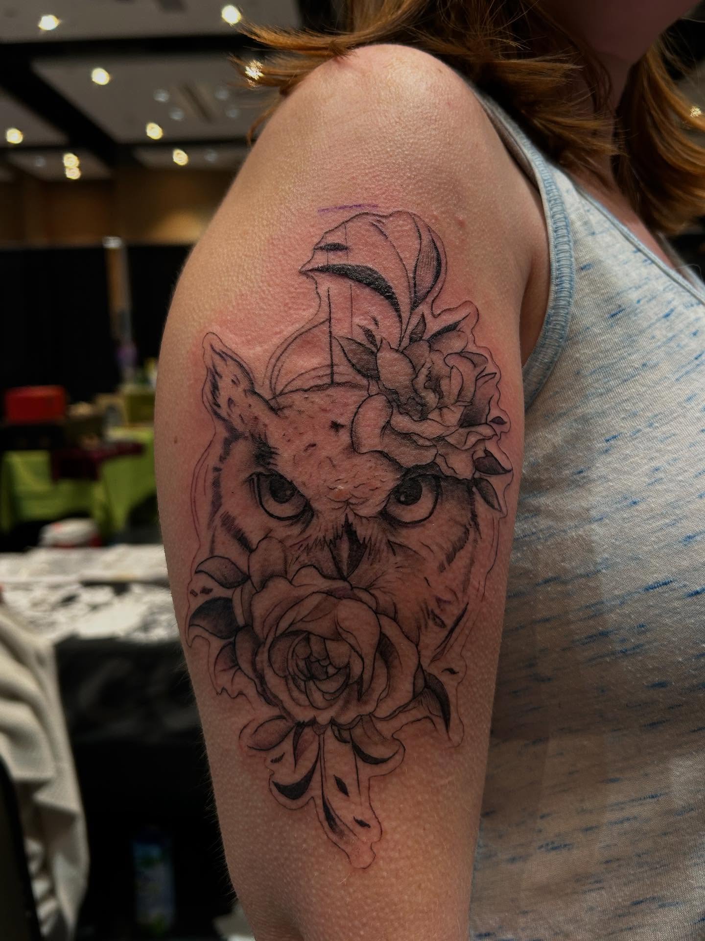 Owl and roses realism tattoo on the upper arm by Cyko Hernandez