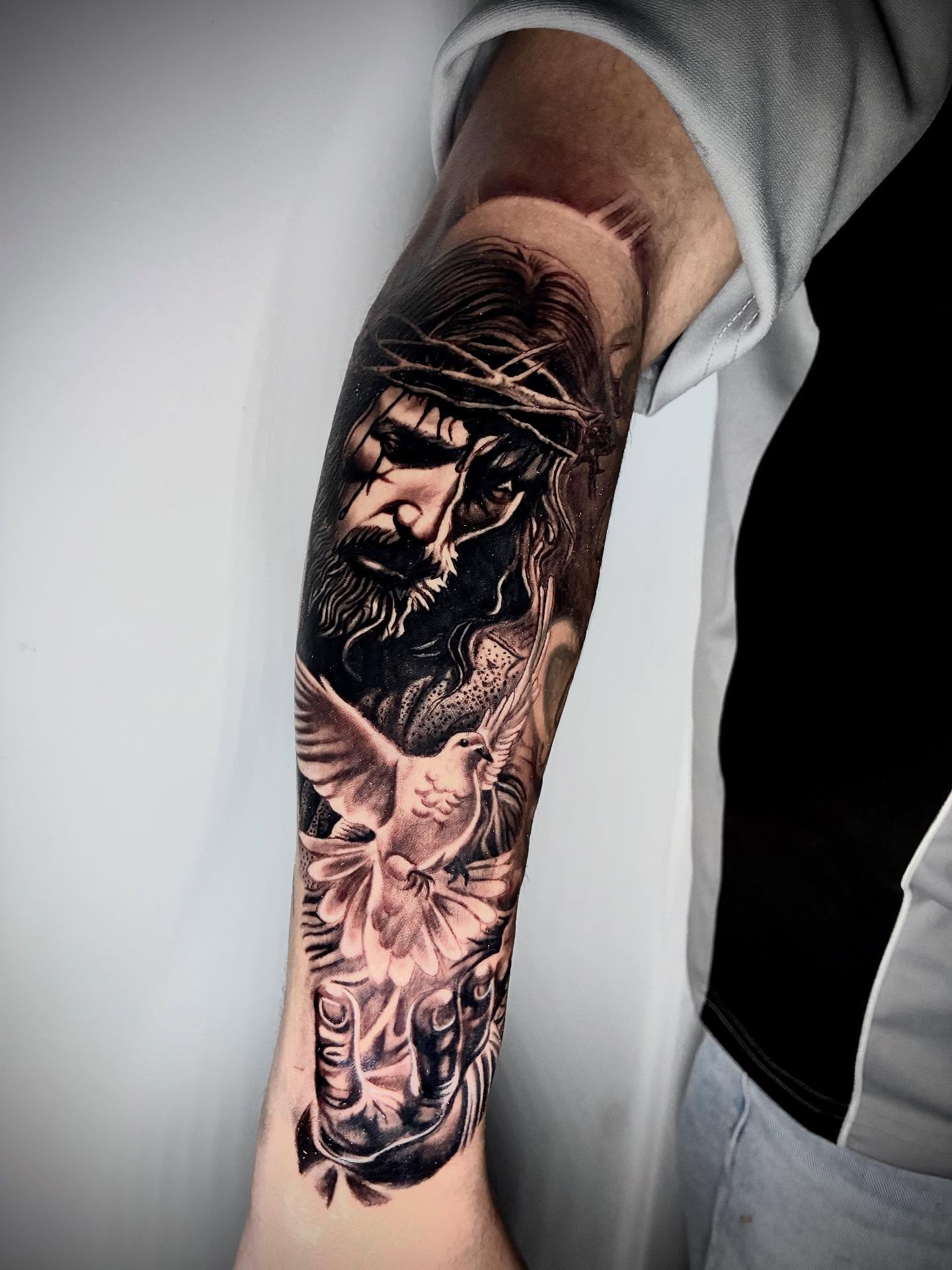 Religious figure with dove realism tattoo on the forearm by Daniel Ruiz