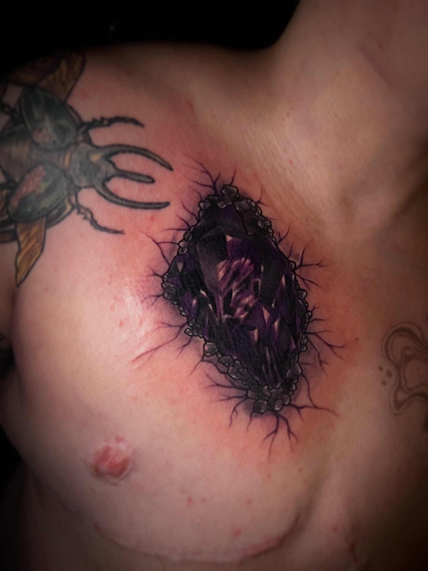 Amethyst crystal realism tattoo on the chest by Em ✨PA Tattooer