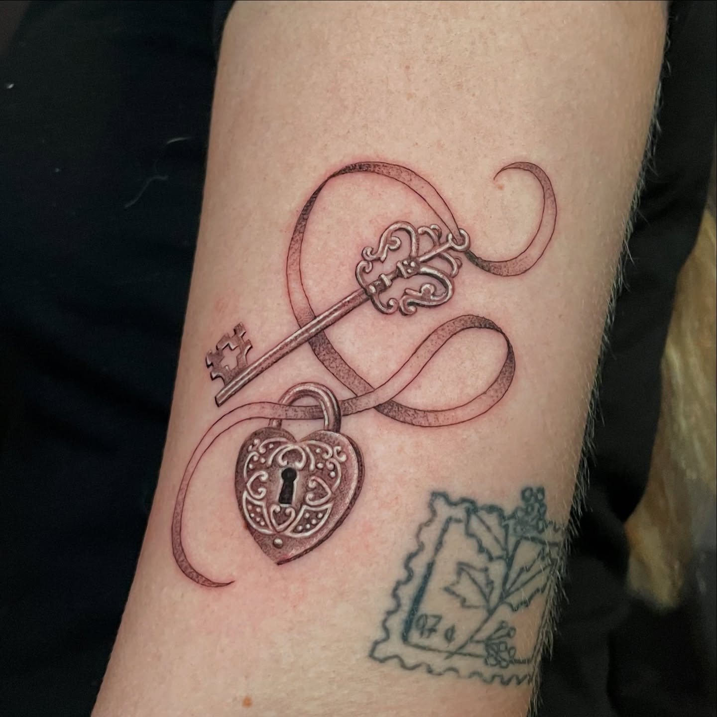Key and heart lock ornamental tattoo on the forearm by Candence Smith