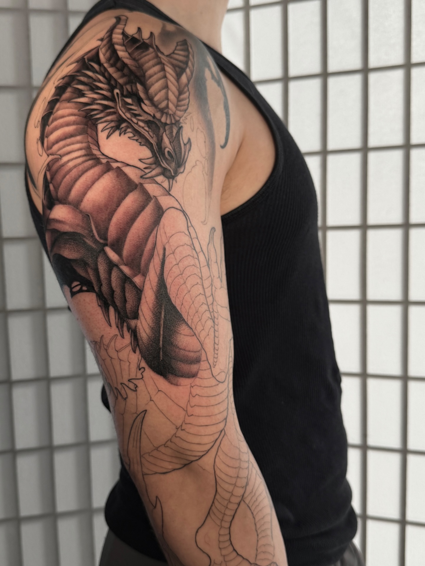 Dragon black and grey tattoo on the upper arm by Carlos Valdes ✨ Tattoo Artist in Tampa FL