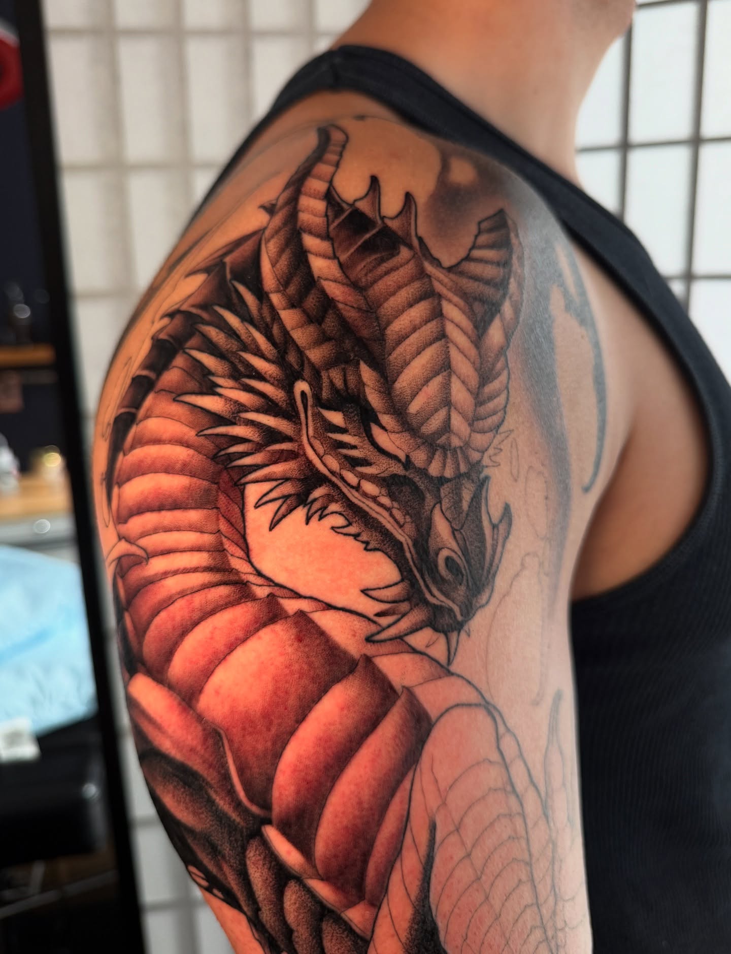 Dragon realism tattoo on the upper arm by Carlos Valdes ✨ Tattoo Artist in Tampa FL