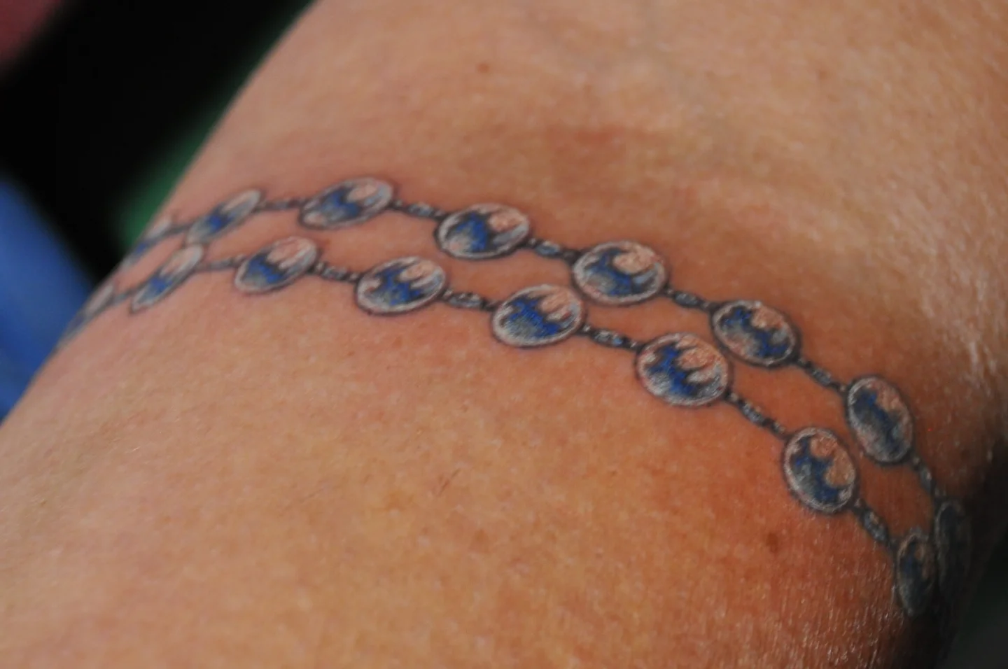 Beads dotwork tattoo on the upper arm by Bek Artz