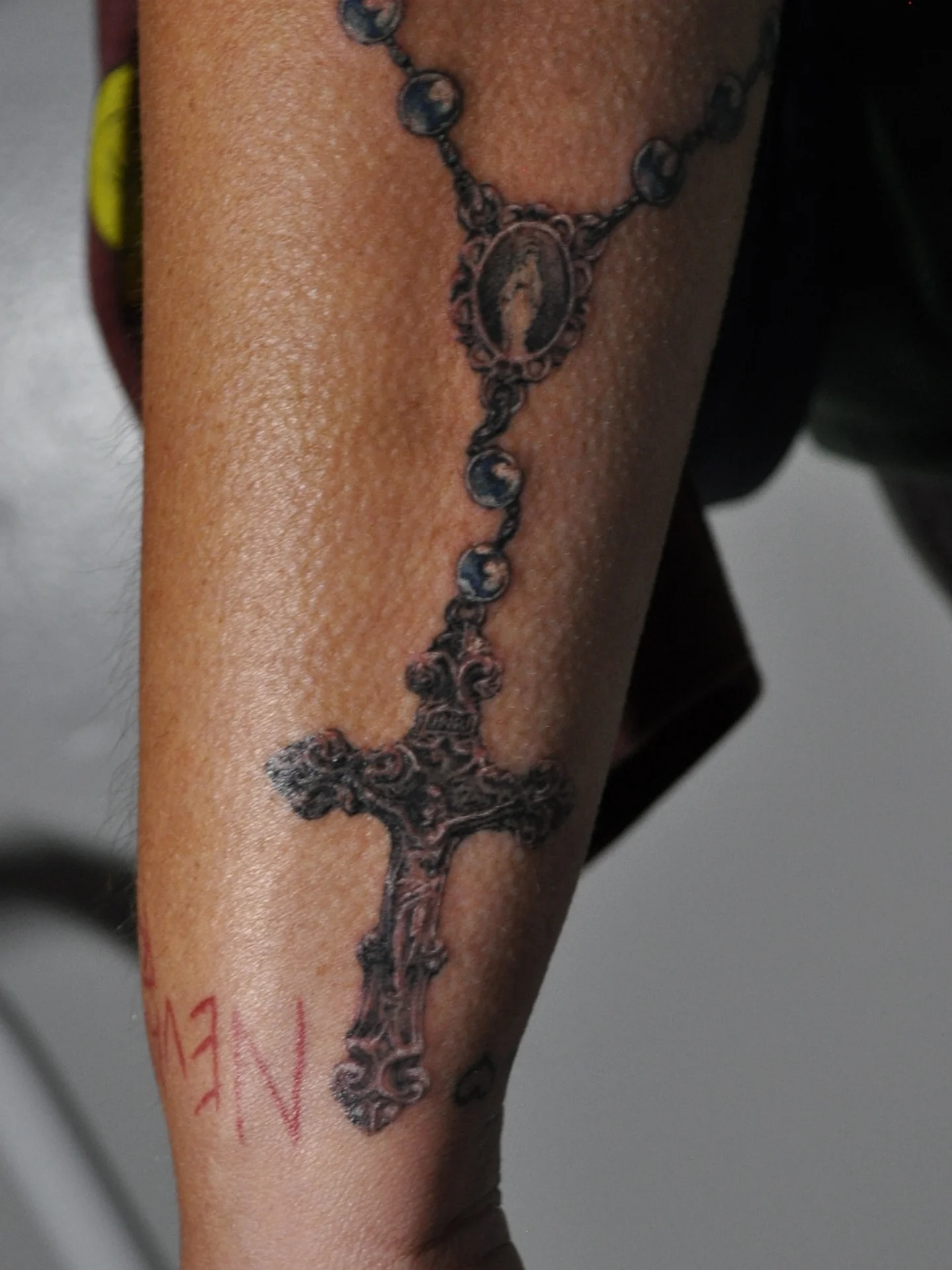 Rosary black and grey tattoo on the forearm by Bek Artz