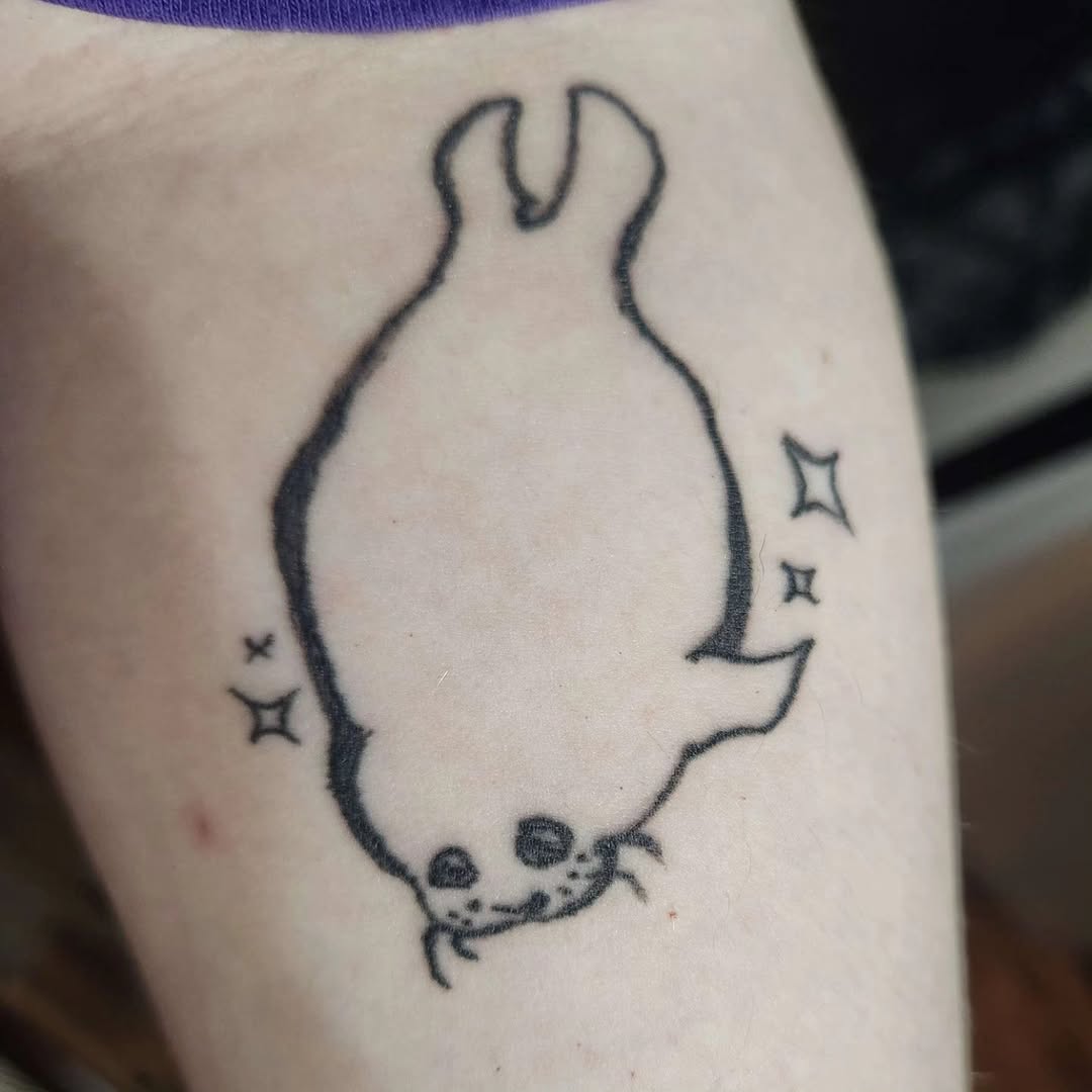 Cute seal with sparkles new school tattoo on the forearm by π«