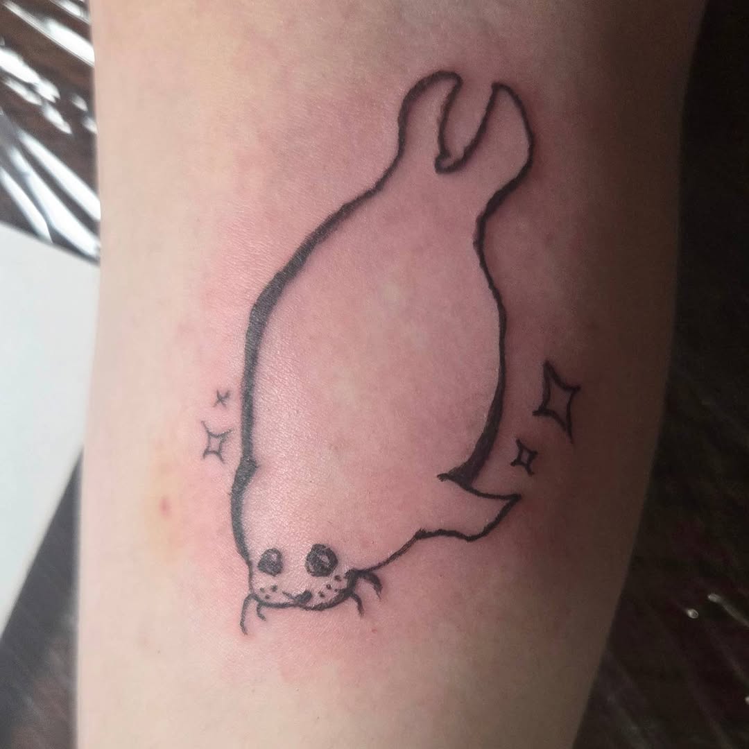 Cute seal with sparkles new school tattoo on the forearm by π«
