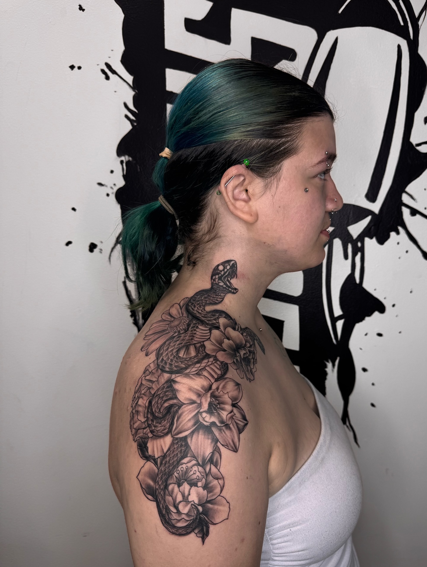 Snake and flowers black and grey tattoo on the shoulder by Chicago Tattoo Artist