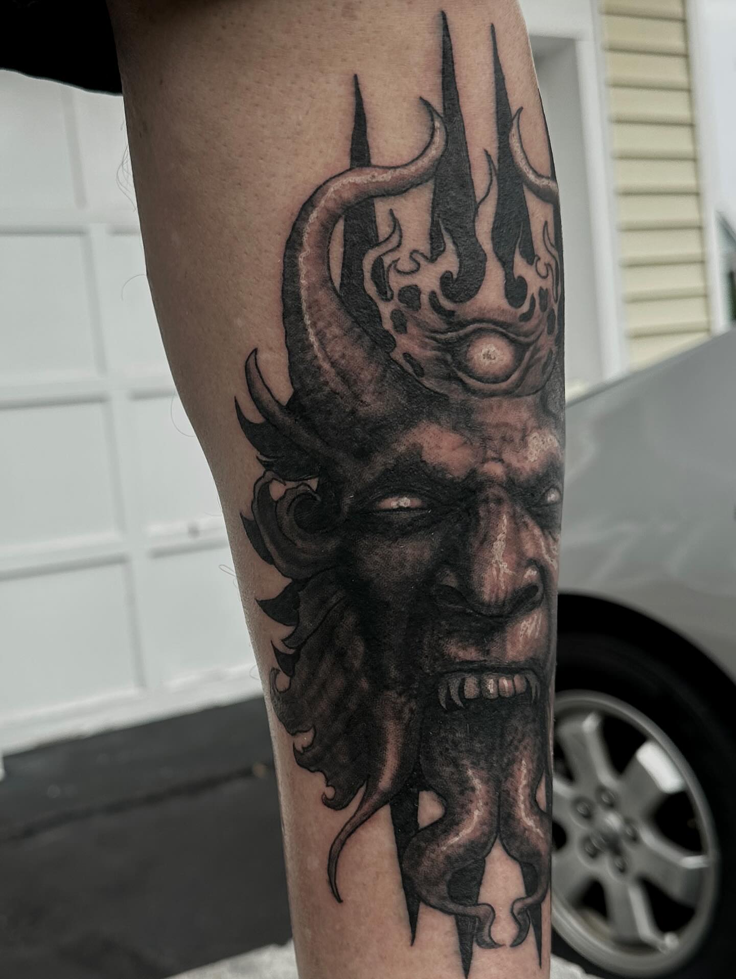 Demon head dark realism tattoo on the forearm by Paul Booth