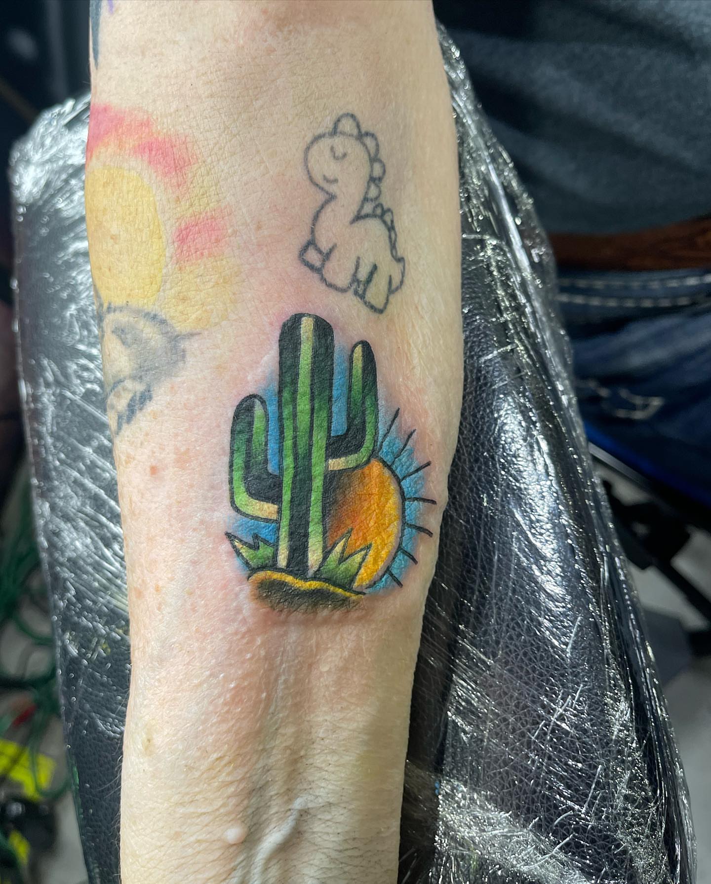 Cactus and sun American traditional tattoo on the forearm by Kodi Klo