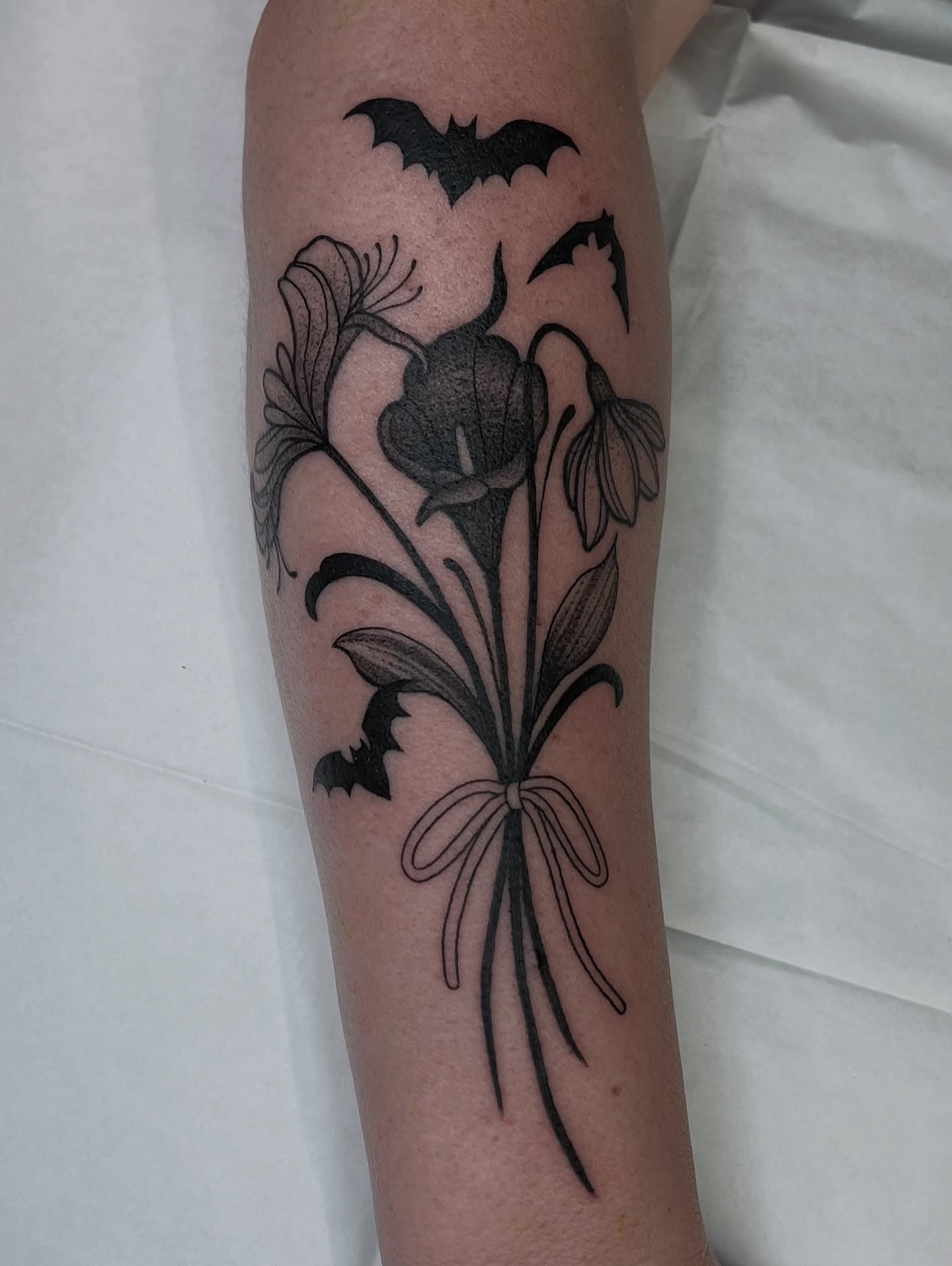 Calla lilies and bats black and grey tattoo on the forearm by ๐๐๐ฅ๐ฅ๐ข๐ ๐๐๐ก๐ข๐ฅ๐ฅ๐ข๐ง๐