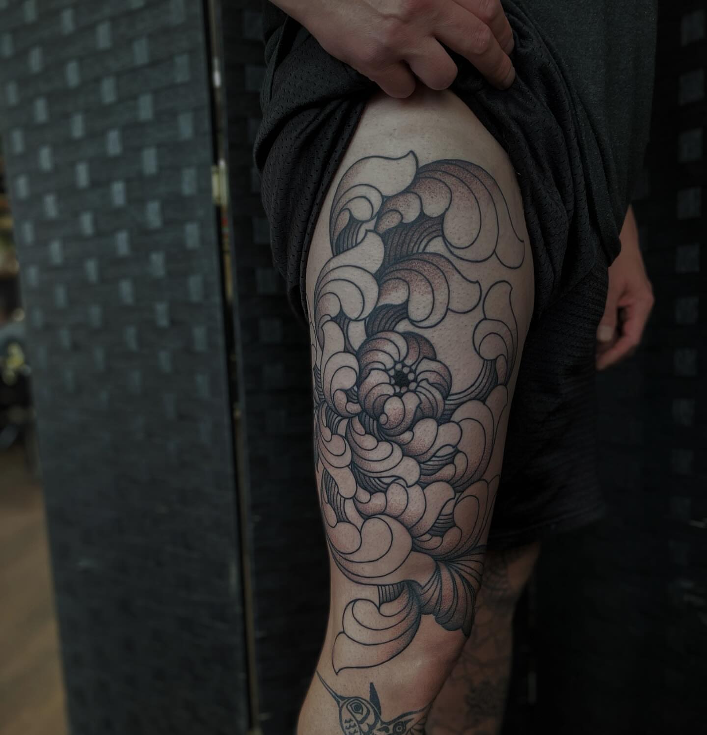 Wave black and grey tattoo on the thigh by Veronica