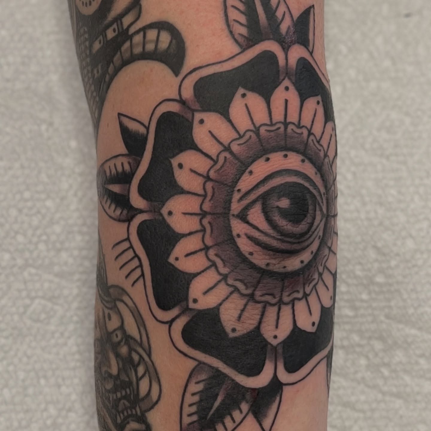 Eye and flower American traditional tattoo on the forearm by @brandonhuckabey, Denver, Colorado
