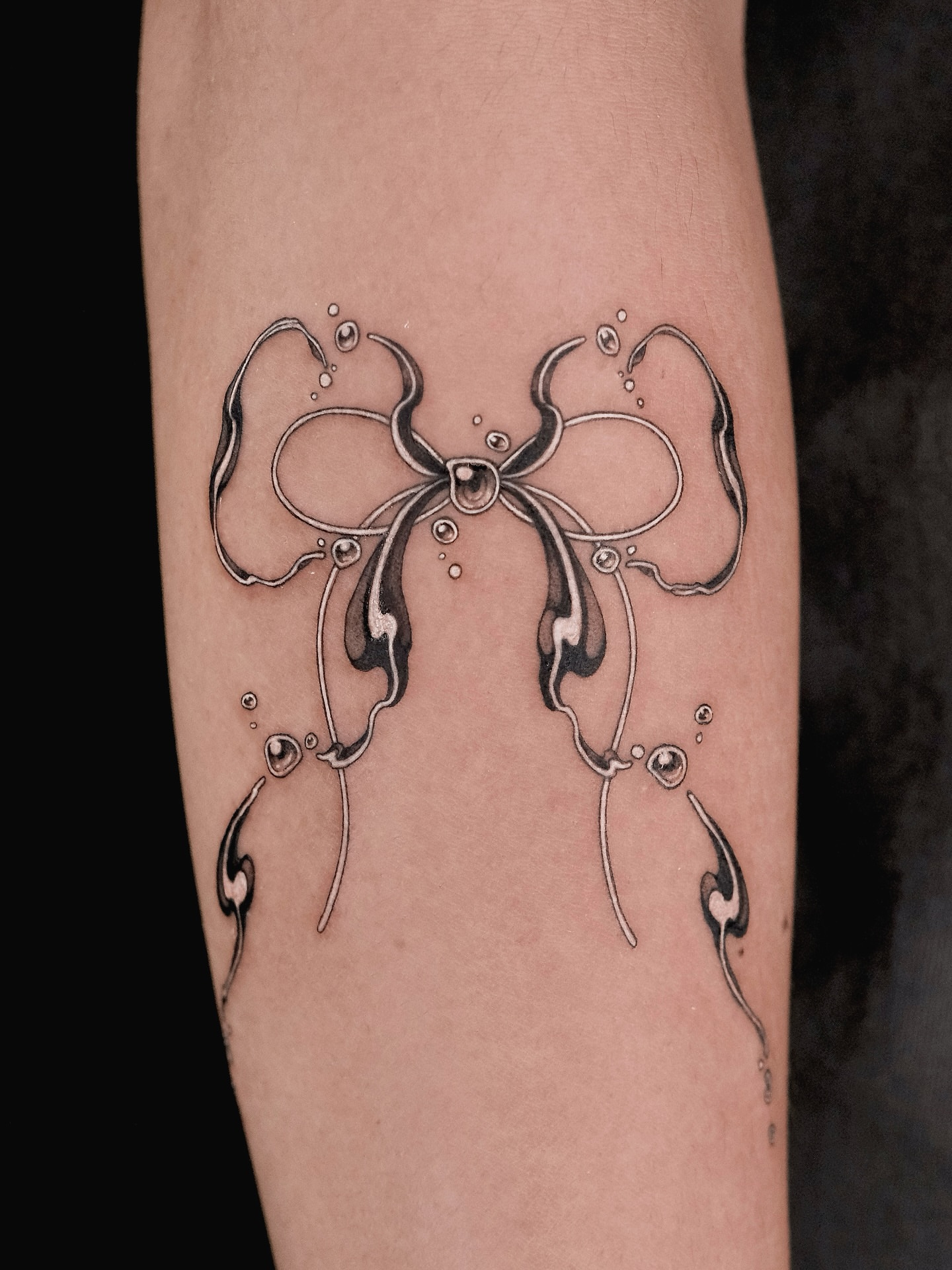 Bow black and grey tattoo on the forearm by p o b i