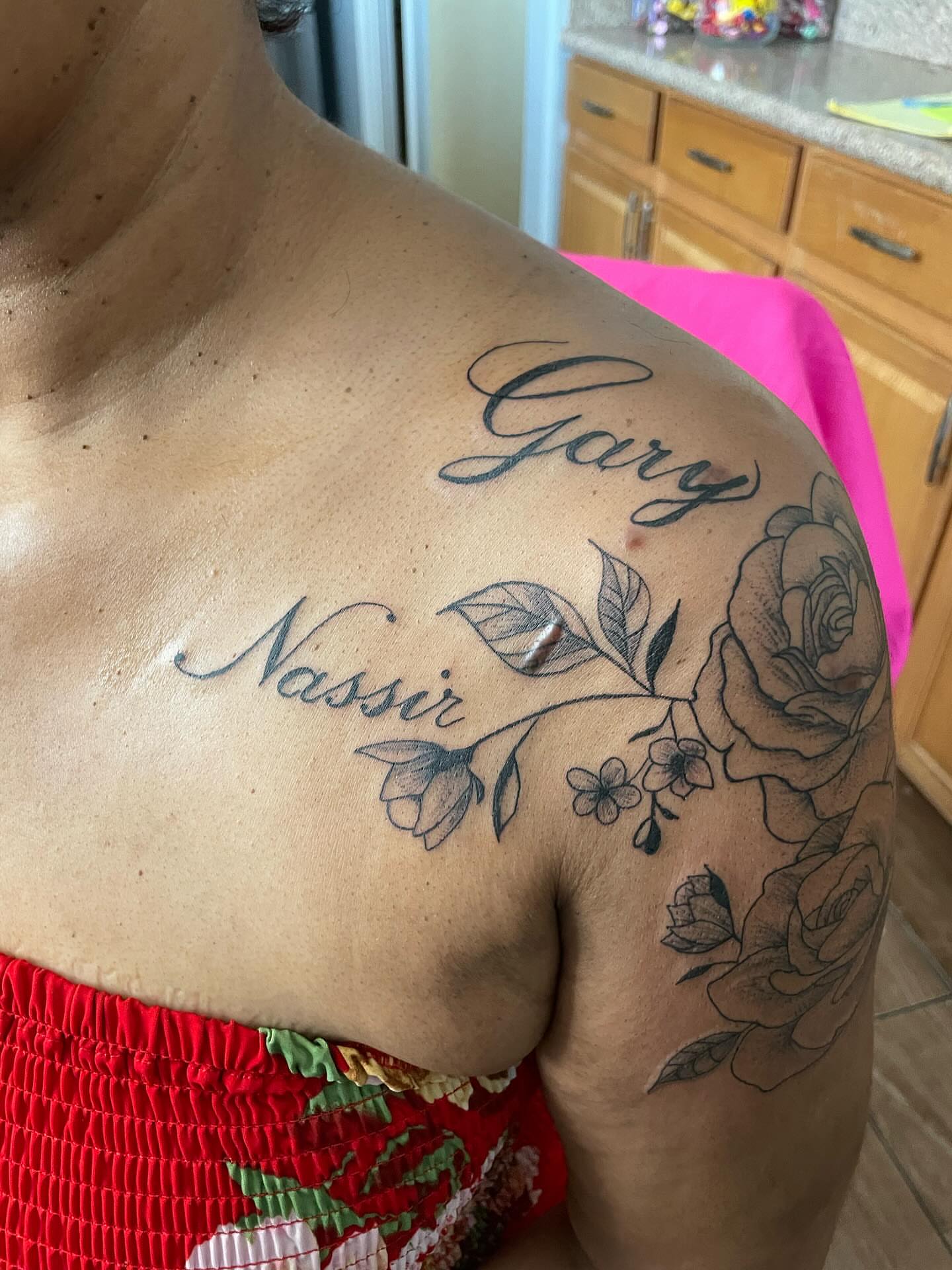 Name and floral design black and grey tattoo on the shoulder by ART