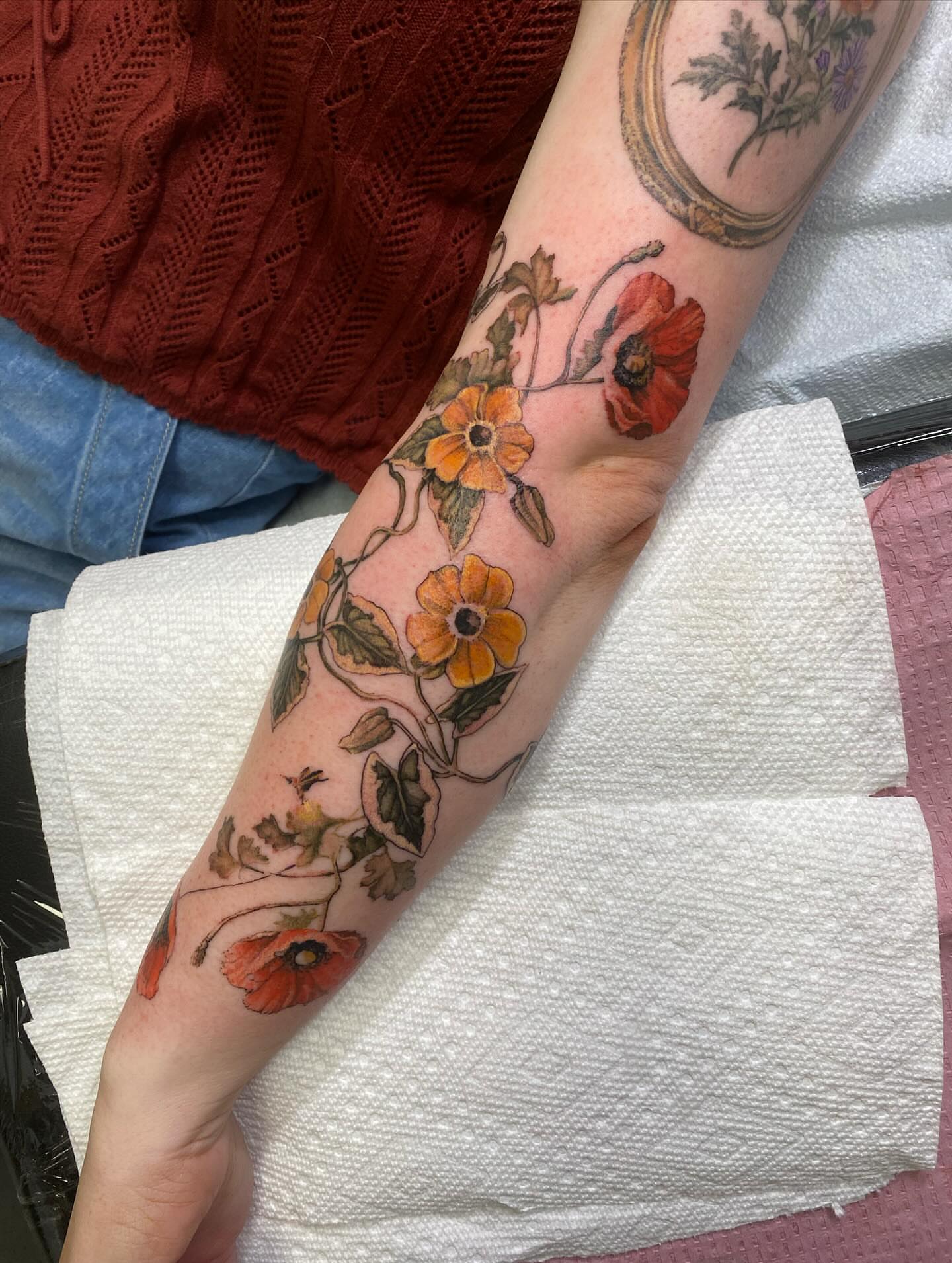 Floral vine watercolor tattoo on the forearm by Amber Miracle