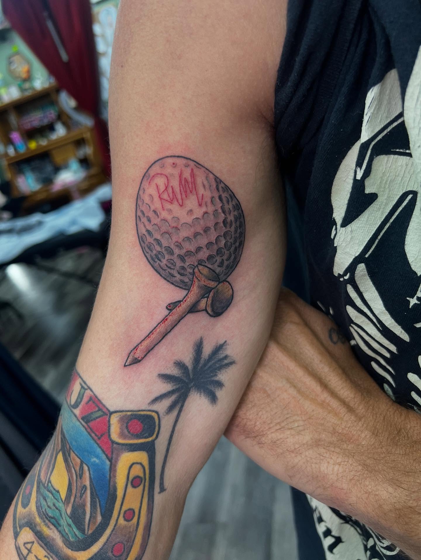 Golf ball and tee realism tattoo on the forearm by Monii Arreola