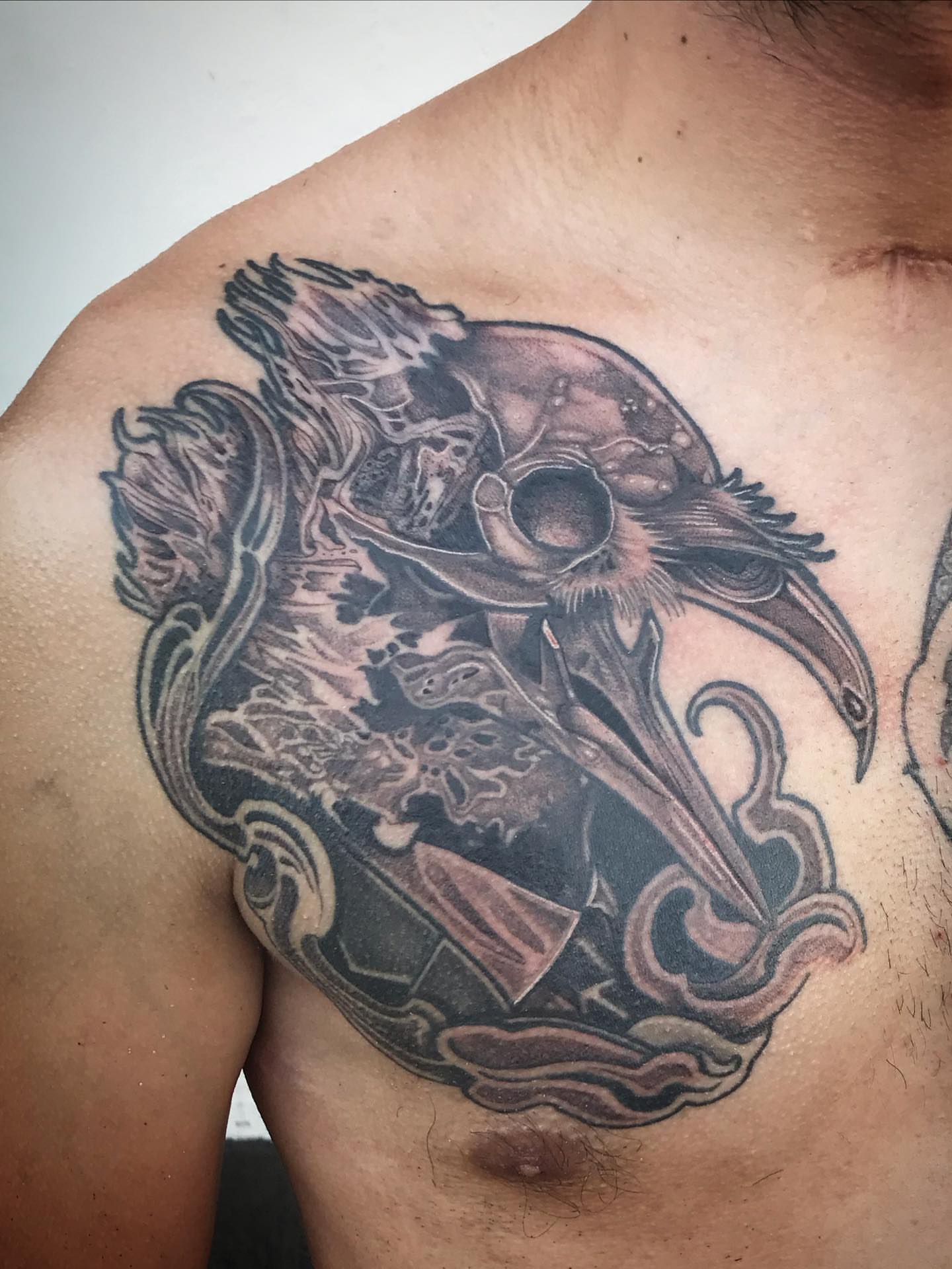 Crow skull dark realism tattoo on the chest by Sean Hollinger