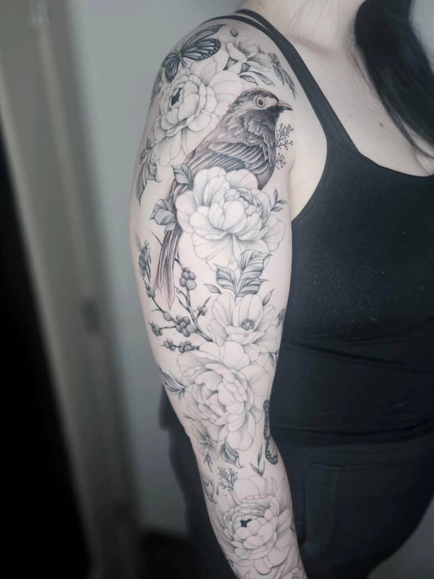 Bird and floral bouquet realism tattoo on the upper arm by TaylorLeighShermanTattoos OFFICIAL