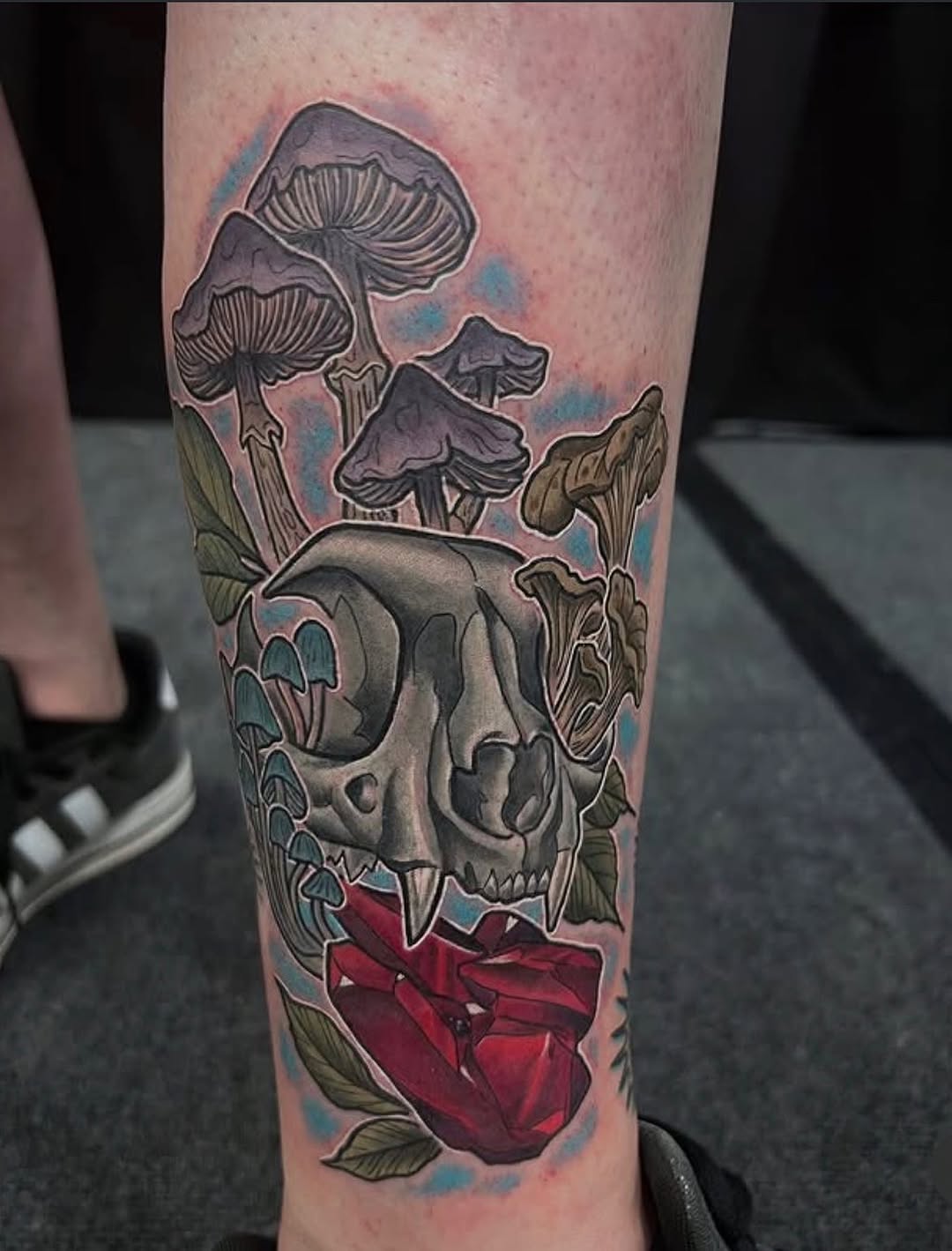 Cat skull with mushrooms and rose American traditional tattoo on the forearm by Joshua Shawn