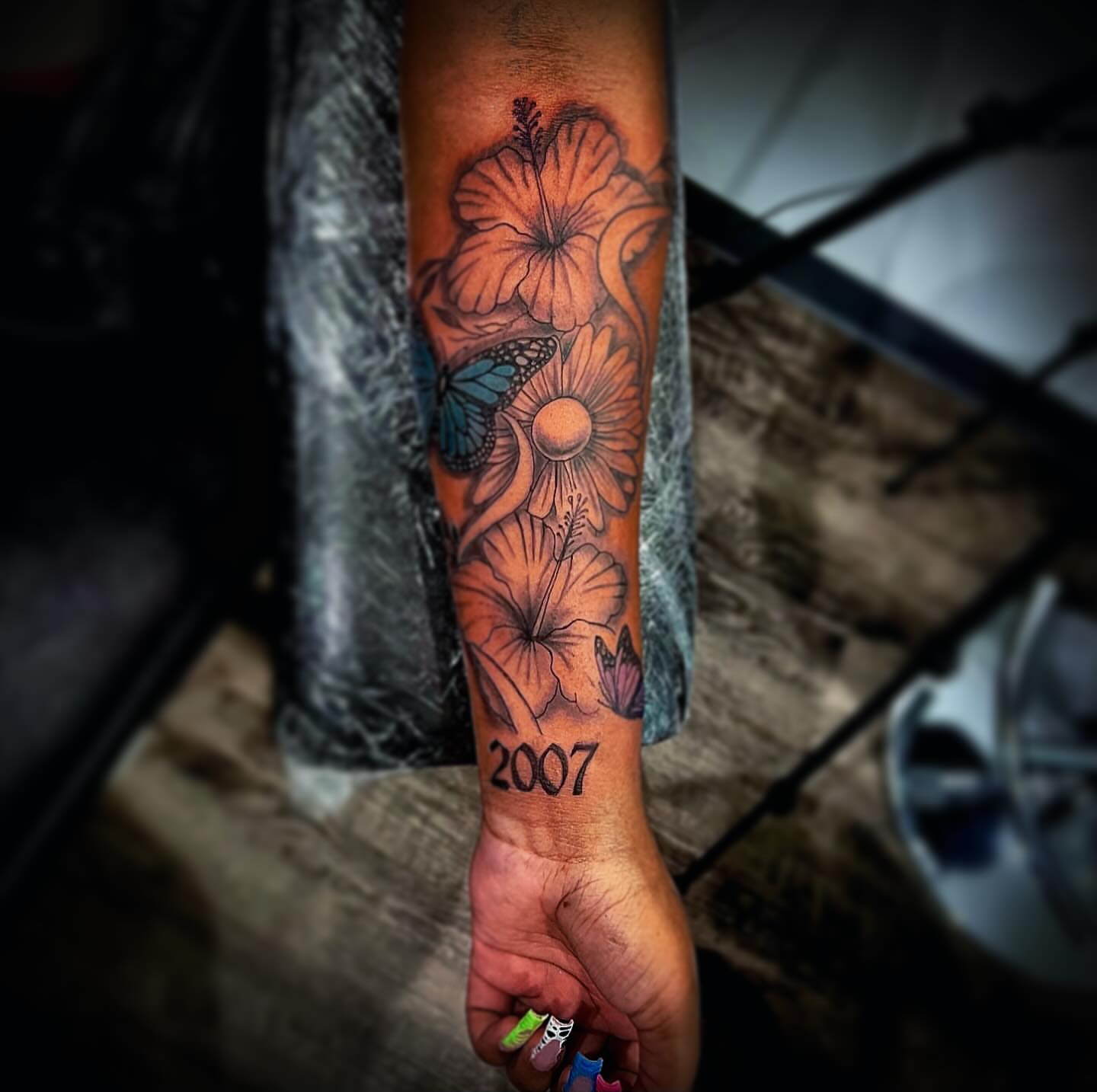 Floral and butterfly design new school tattoo on the forearm by @tattsbyleek