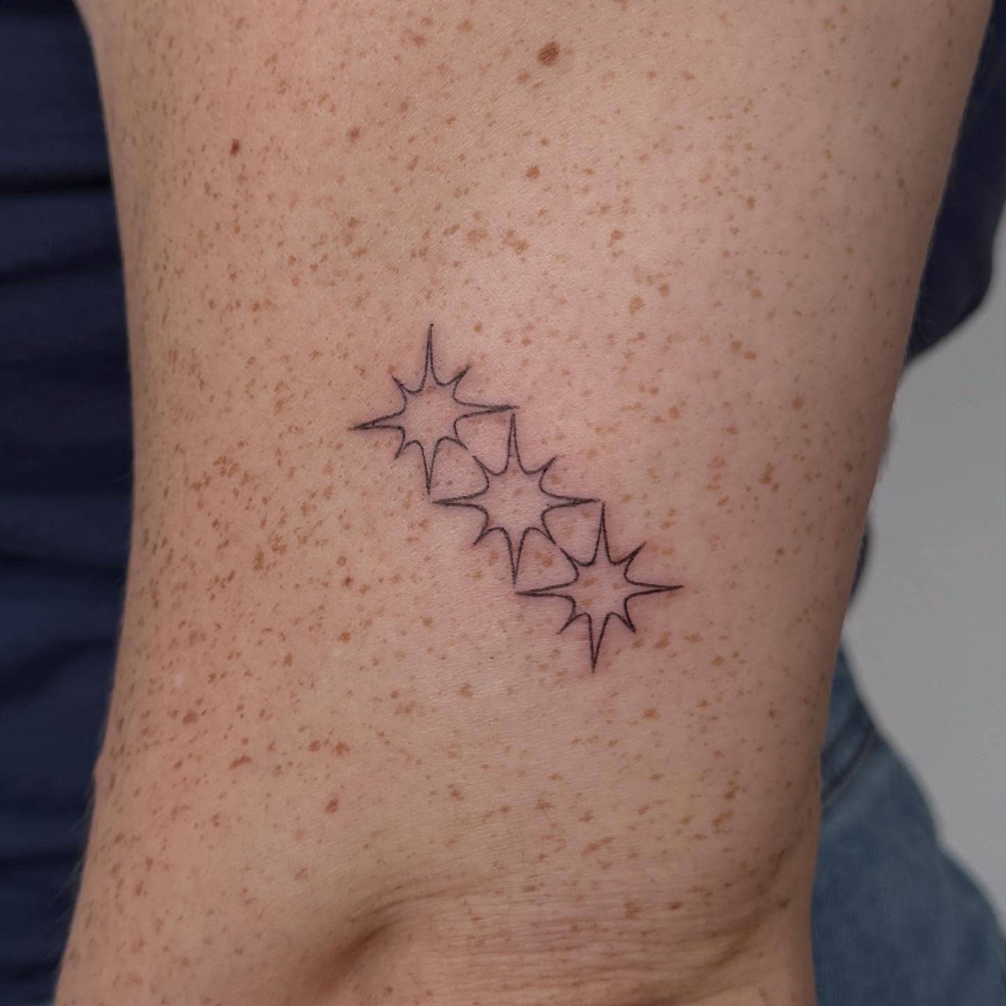 Stars minimalist tattoo on the forearm by Kirsten