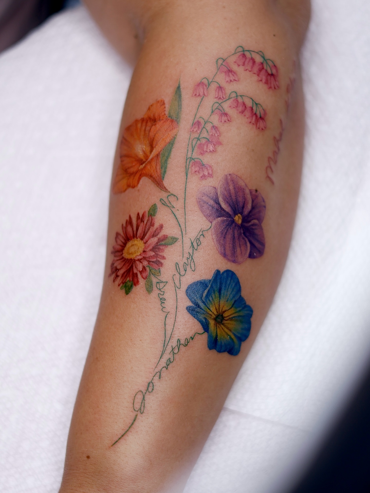 Floral arrangement watercolor tattoo on the forearm by Júlia Sorrino