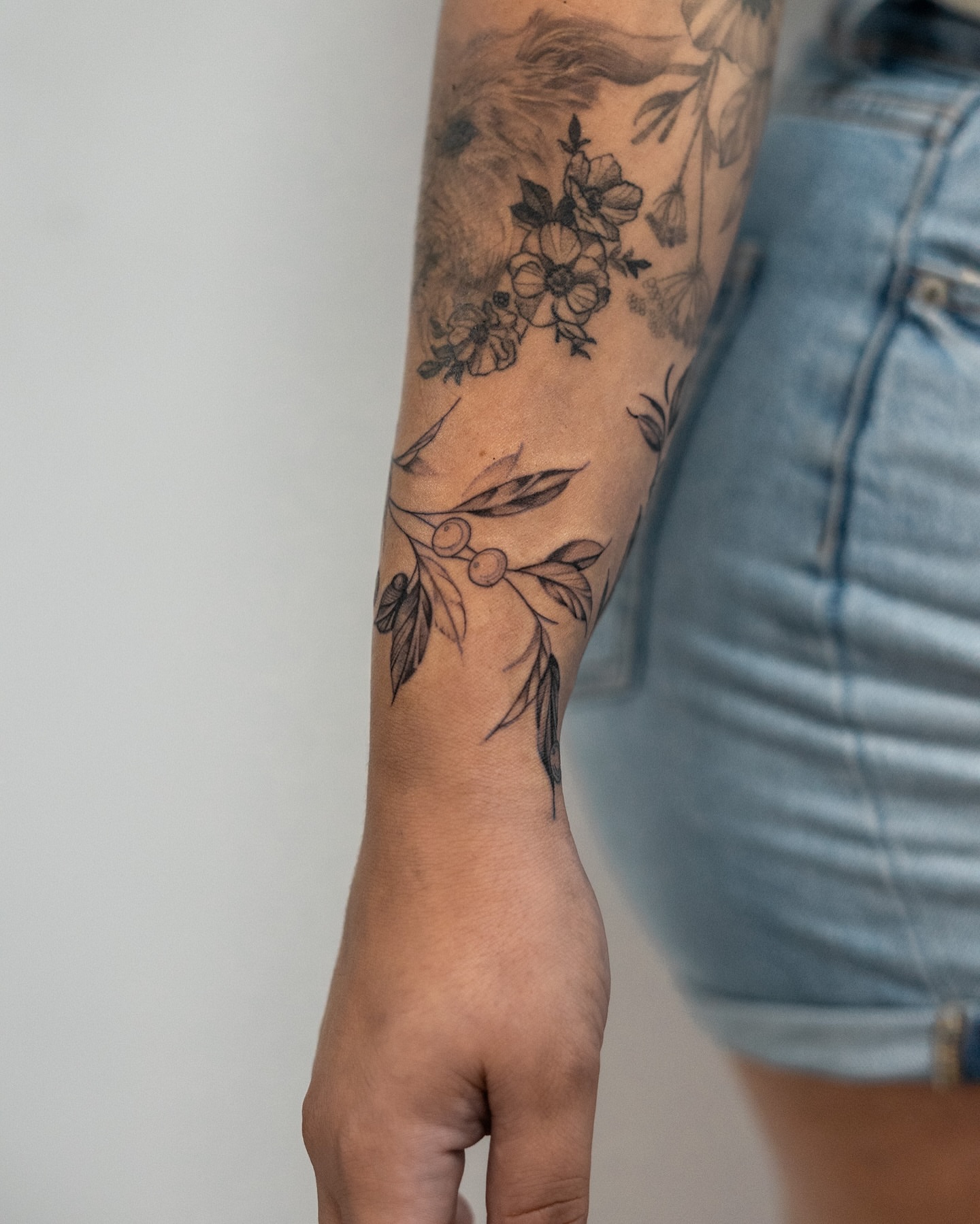 Floral arrangement black and grey tattoo on the forearm by The Tattoo Plug