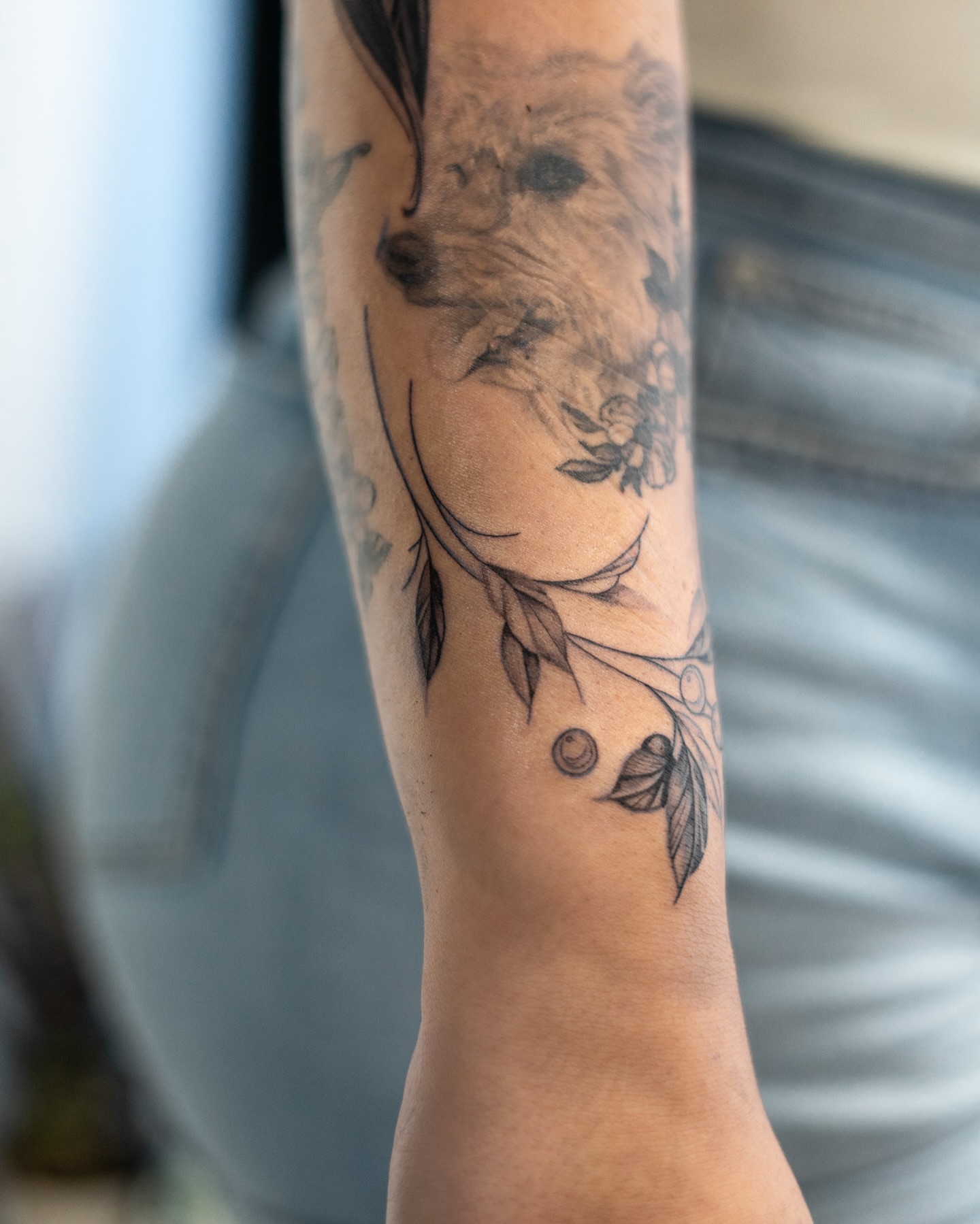 Floral design black and grey tattoo on the forearm by The Tattoo Plug