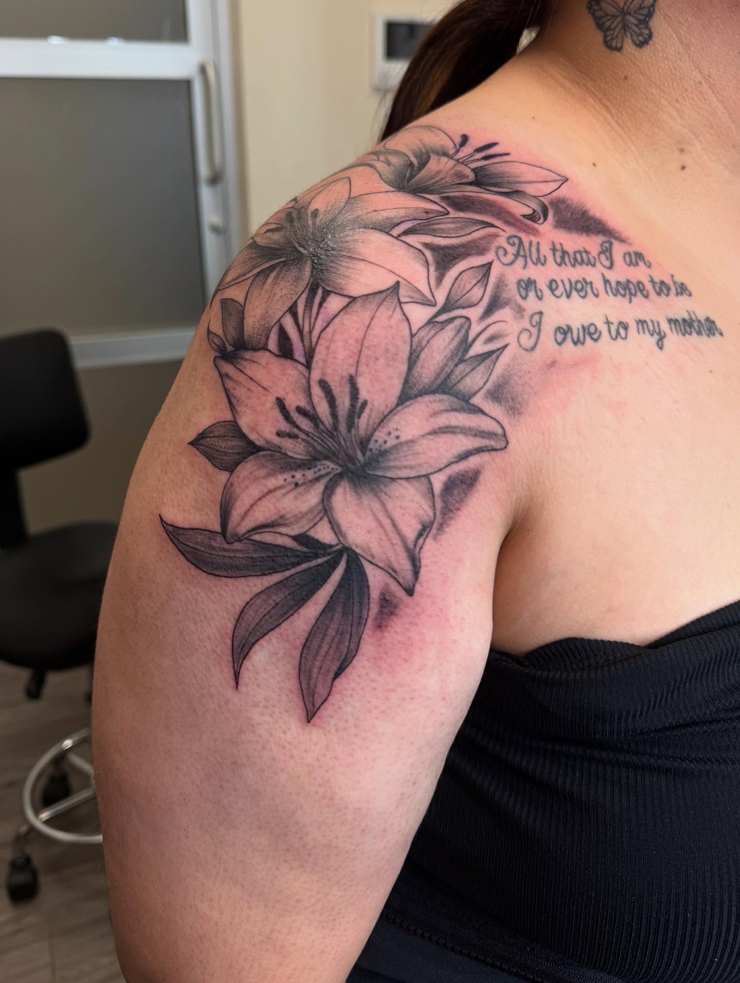 Lilies black and grey tattoo on the shoulder by Gladys L.