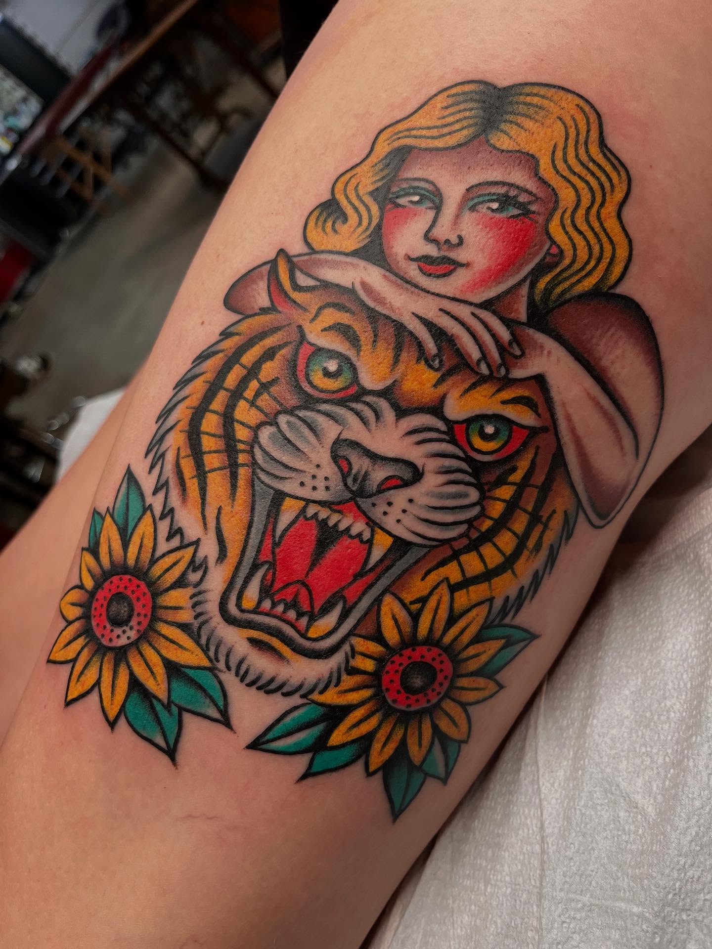 Woman with tiger and sunflowers American traditional tattoo on the forearm by ๐๐ฎ๐ฌ๐ญ๐ข๐ง ๐๐จ๐ฐ๐๐ซ๐, Oakland, California