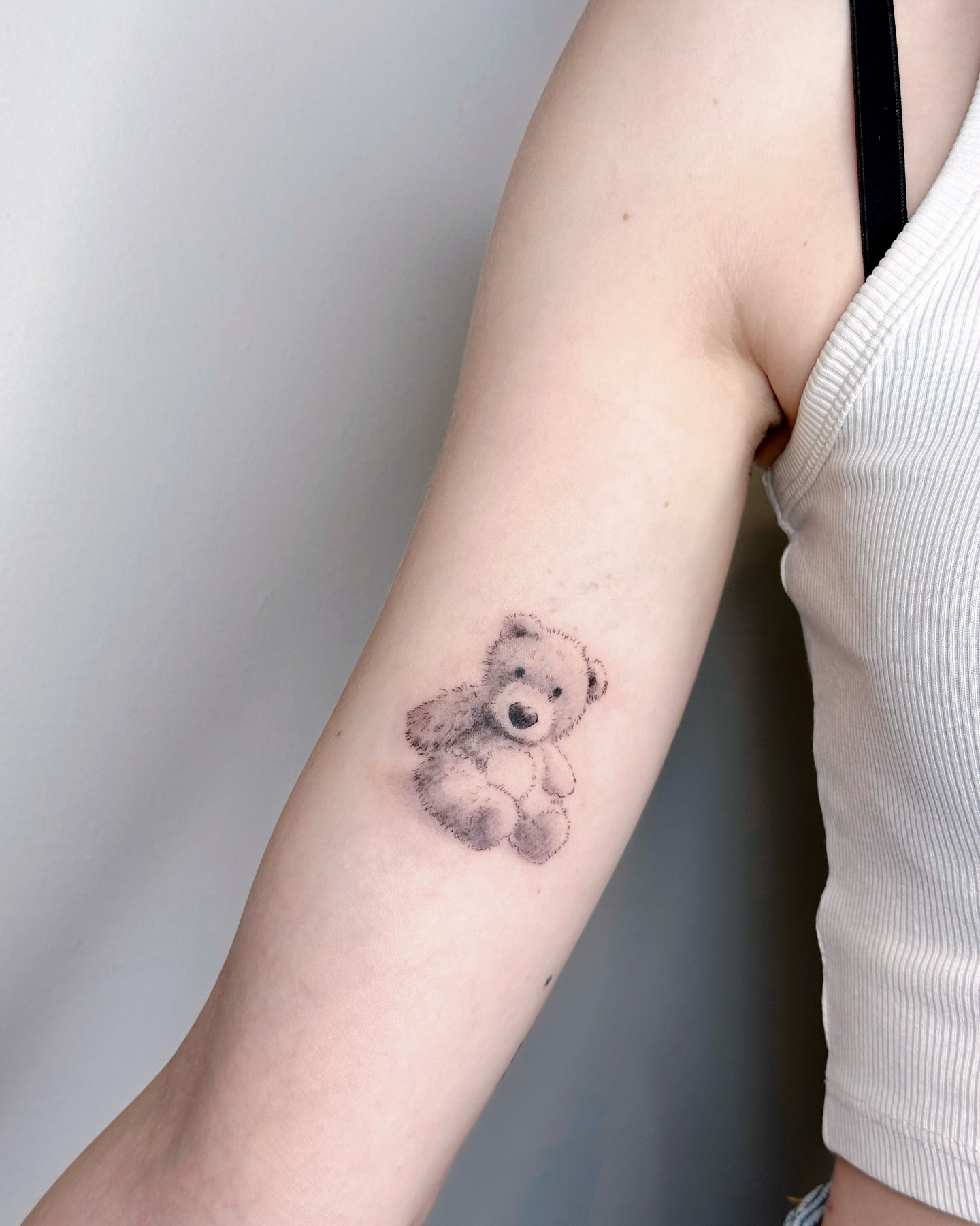 Teddy bear black and grey tattoo on the forearm by Sylvia｜思岐, Vancouver, British Columbia