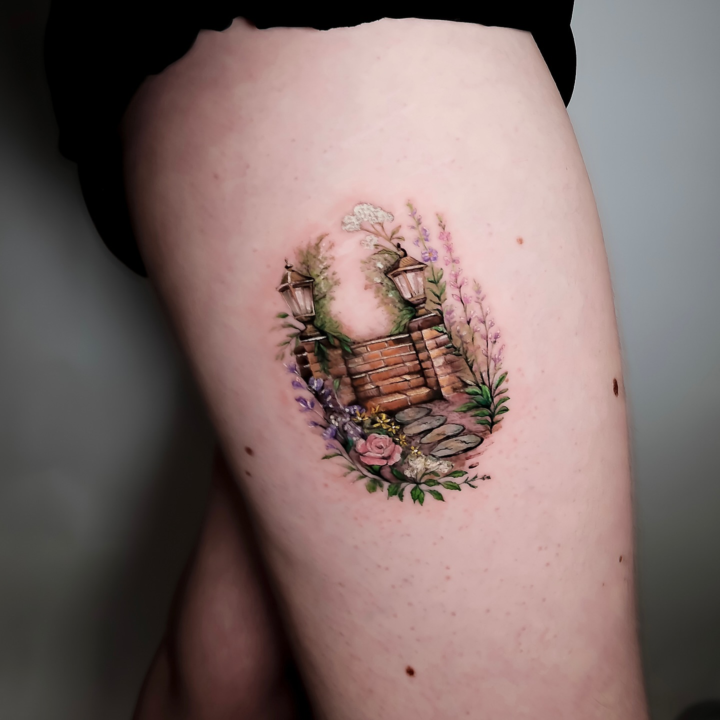 Garden gate watercolor tattoo on the thigh by NAS