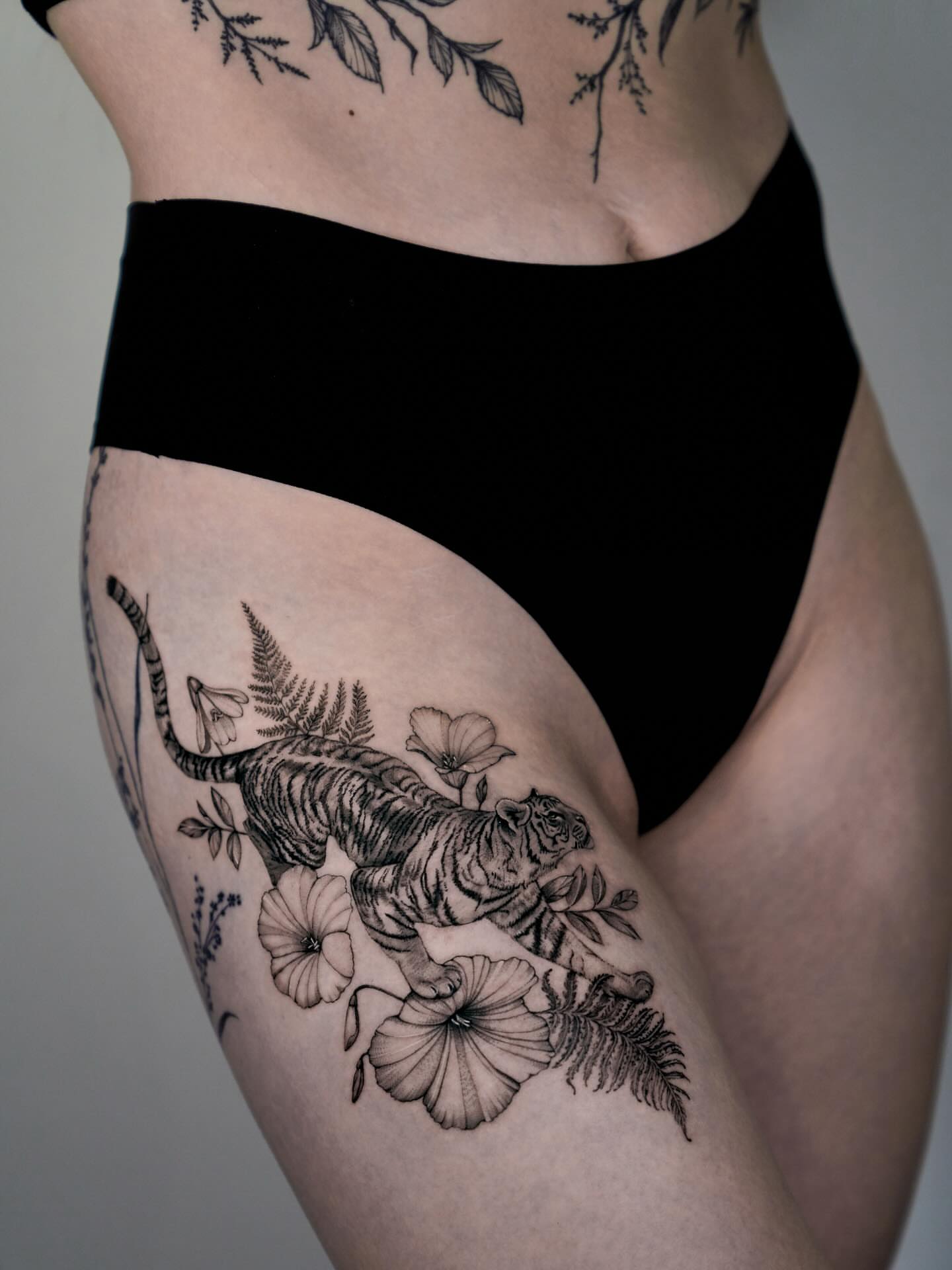 Tiger and flowers black and grey tattoo on the thigh by Tattoo artist LA ། Fine line, Micro realism