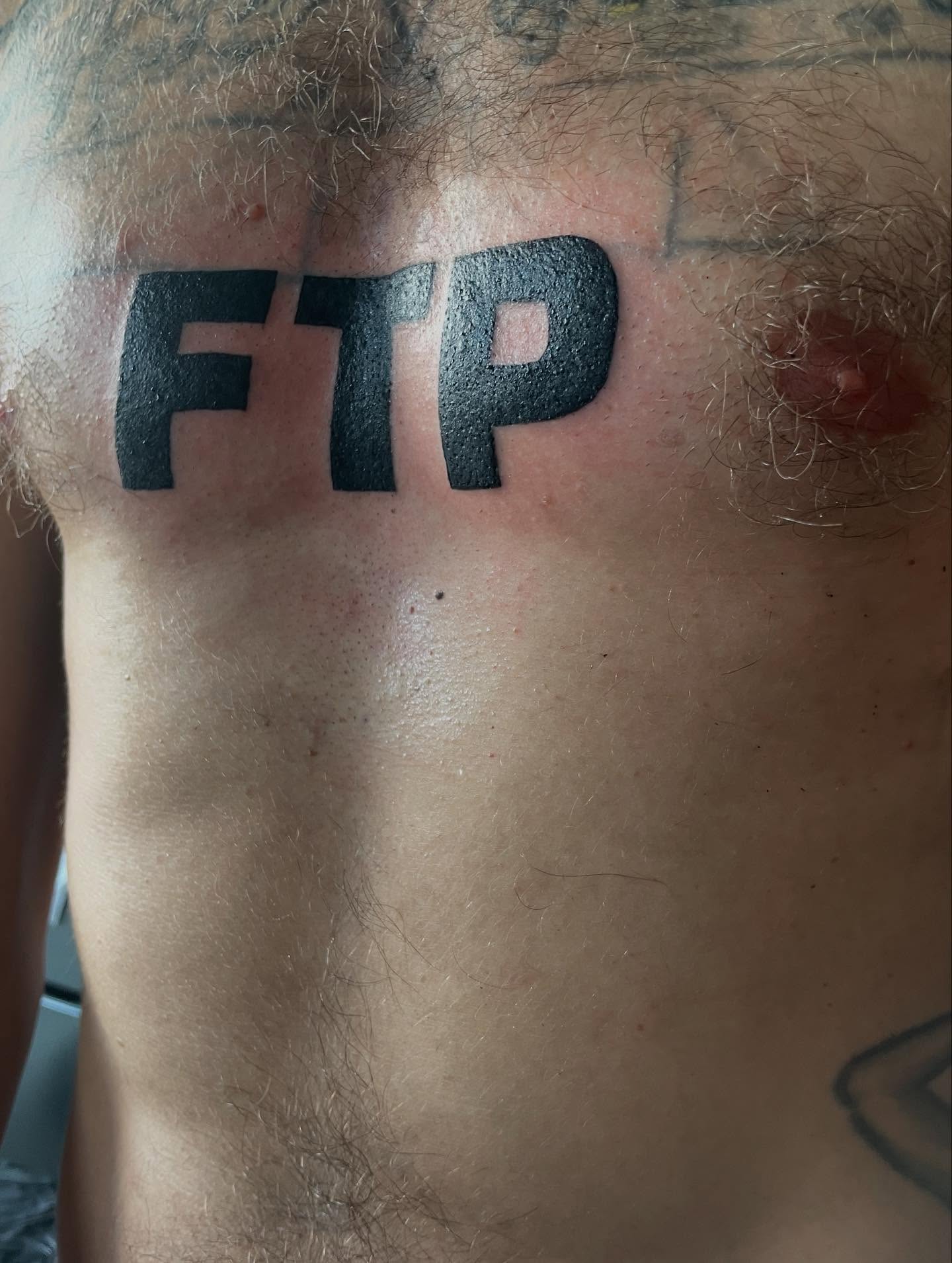 FTP lettering script tattoo on the chest by lu ๐