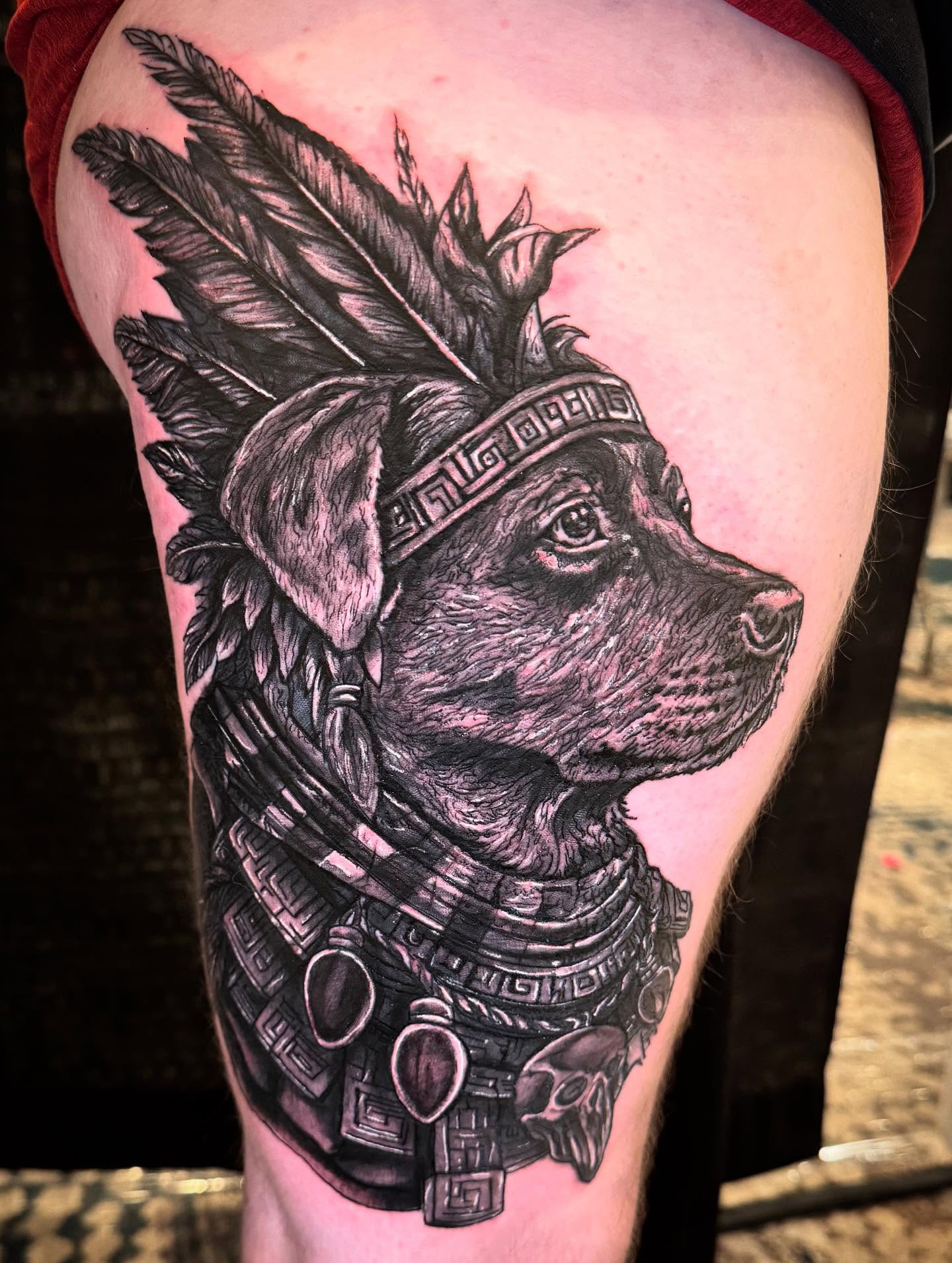 Dog with feather headdress realism tattoo on the thigh by Therapy ink