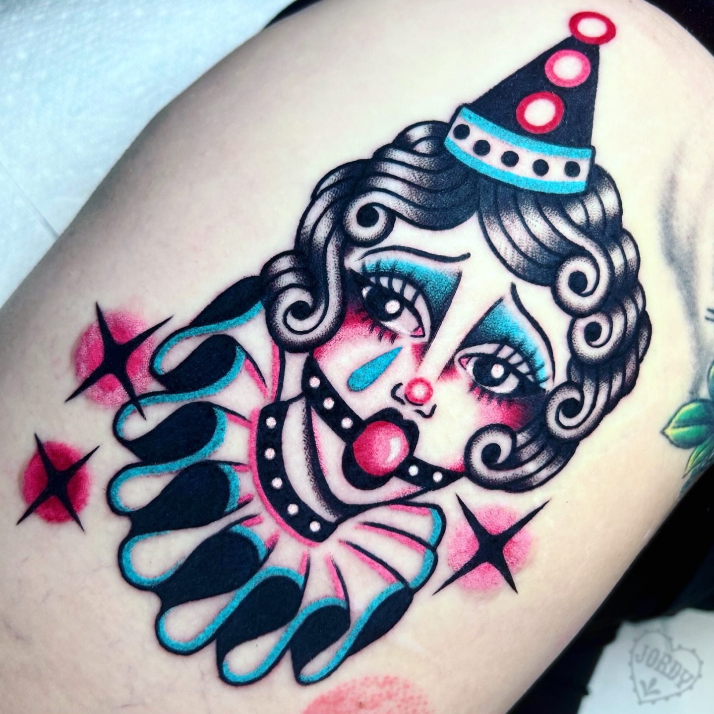 Clown face American traditional tattoo on the thigh by jordy, Philadelphia, Pennsylvania