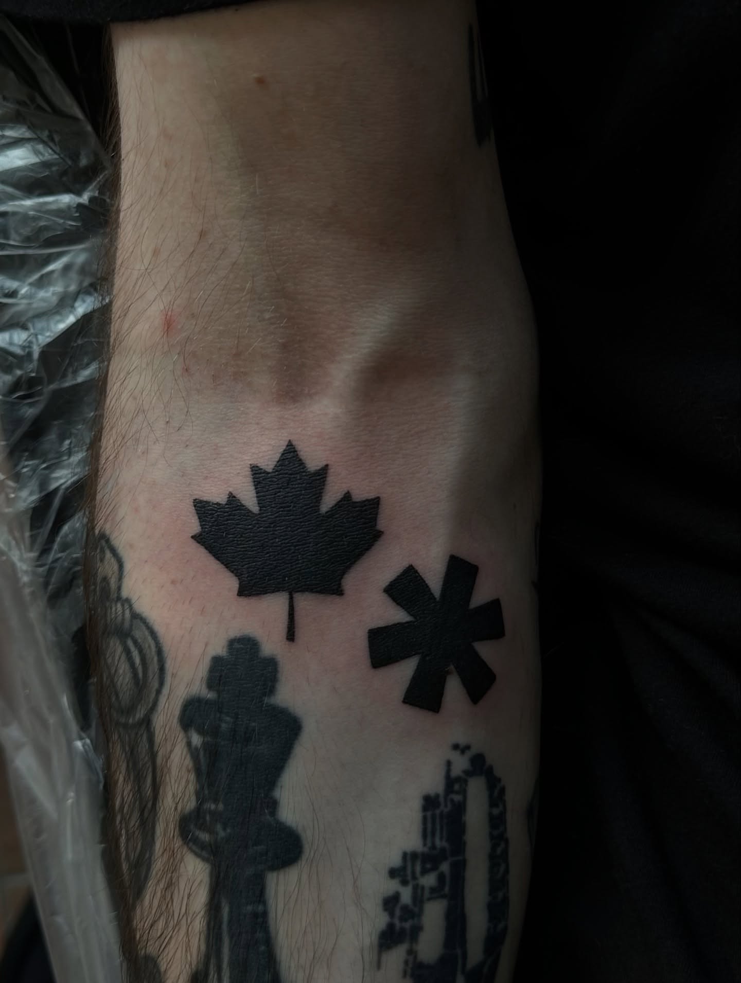 Maple leaf and star black and grey tattoo on the forearm by Casper Tattoos Toronto