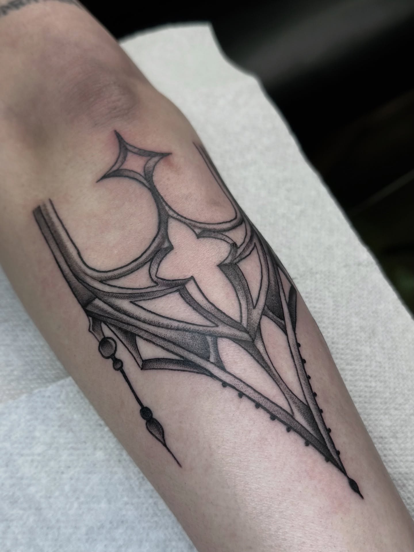 Geometric spiderweb geometric tattoo on the forearm by hannah vertal
