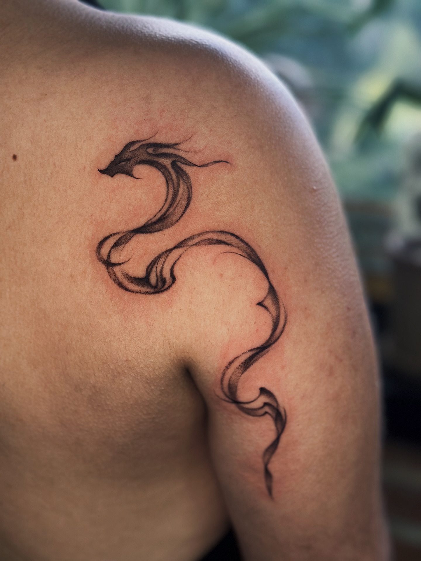 Serpent black and grey tattoo on the shoulder by Lauryn Jenesis