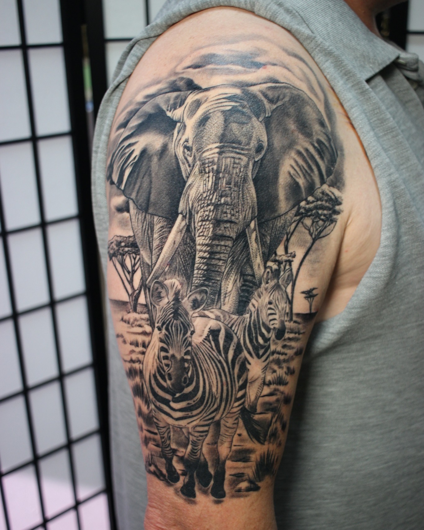 Elephant and zebras realism tattoo on the upper arm by Dustin Quillen Tattoo Artist, Campbellsville, Kentucky