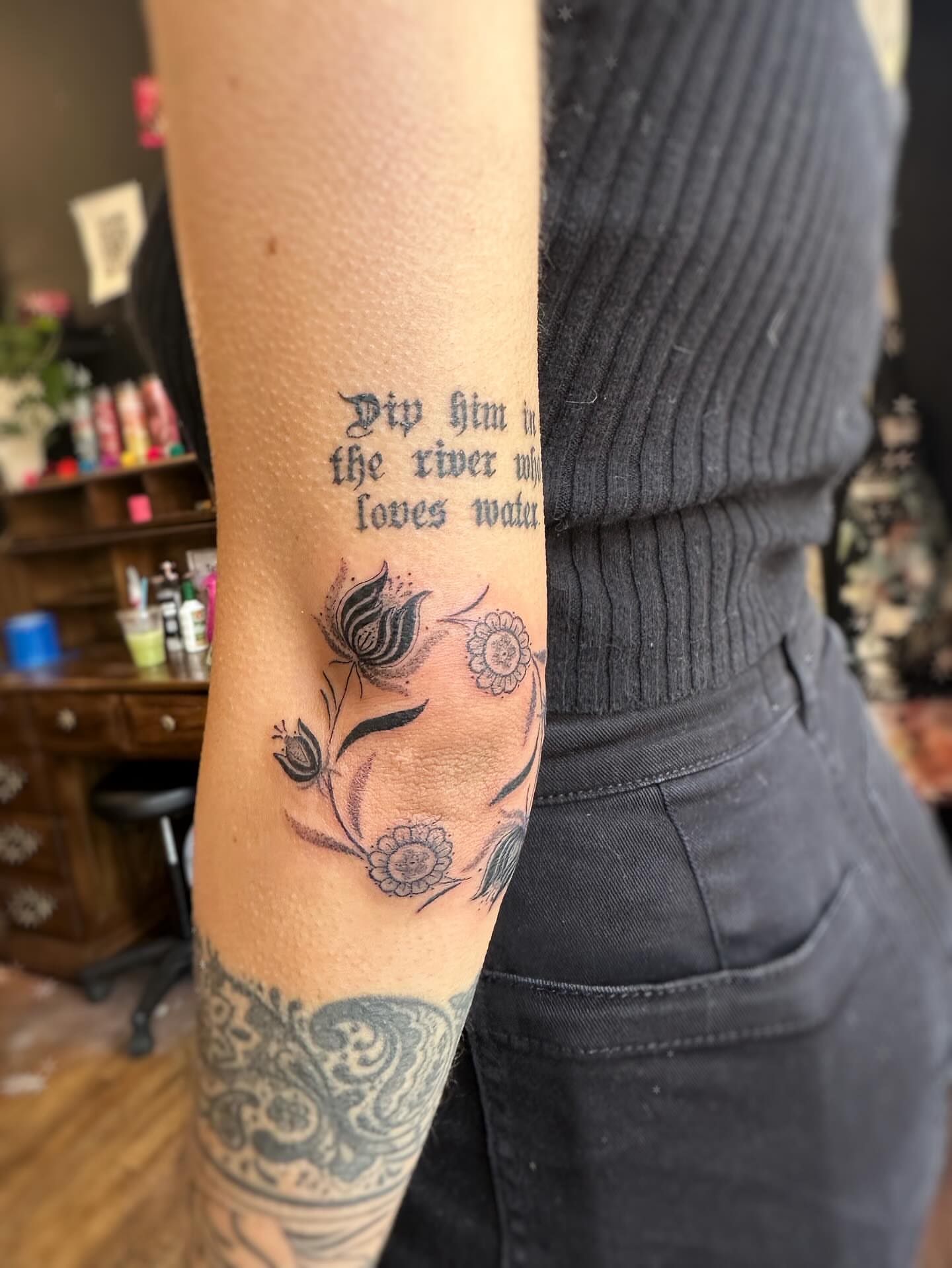 Flower and script black and grey tattoo on the forearm by J Valentin