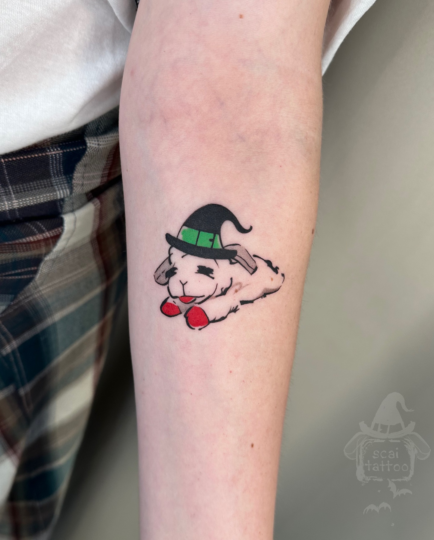 Sheep wearing hat illustrative tattoo on the forearm by scaitattoo