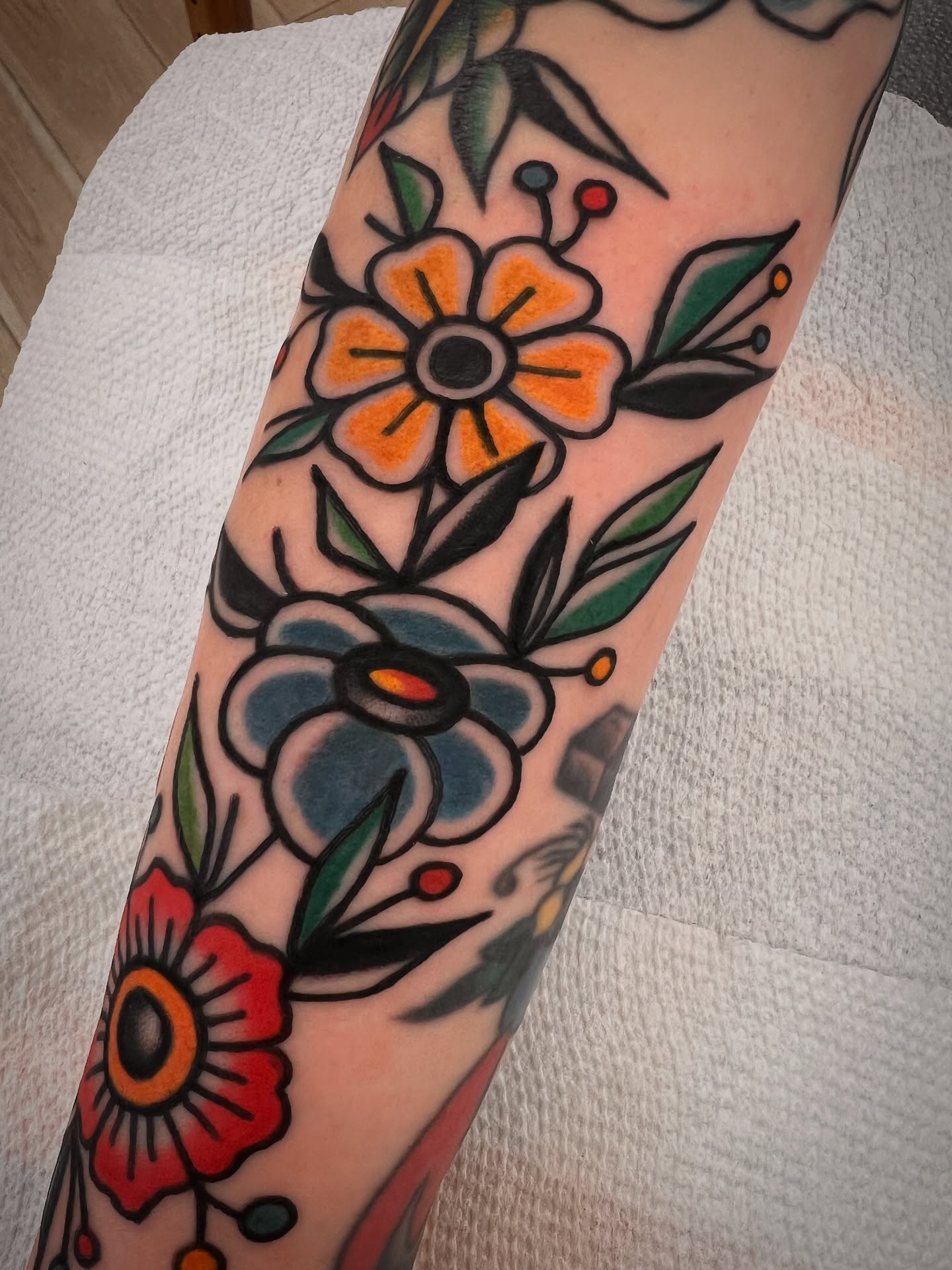 Floral arrangement American traditional tattoo on the forearm by Shannon Pagliarini