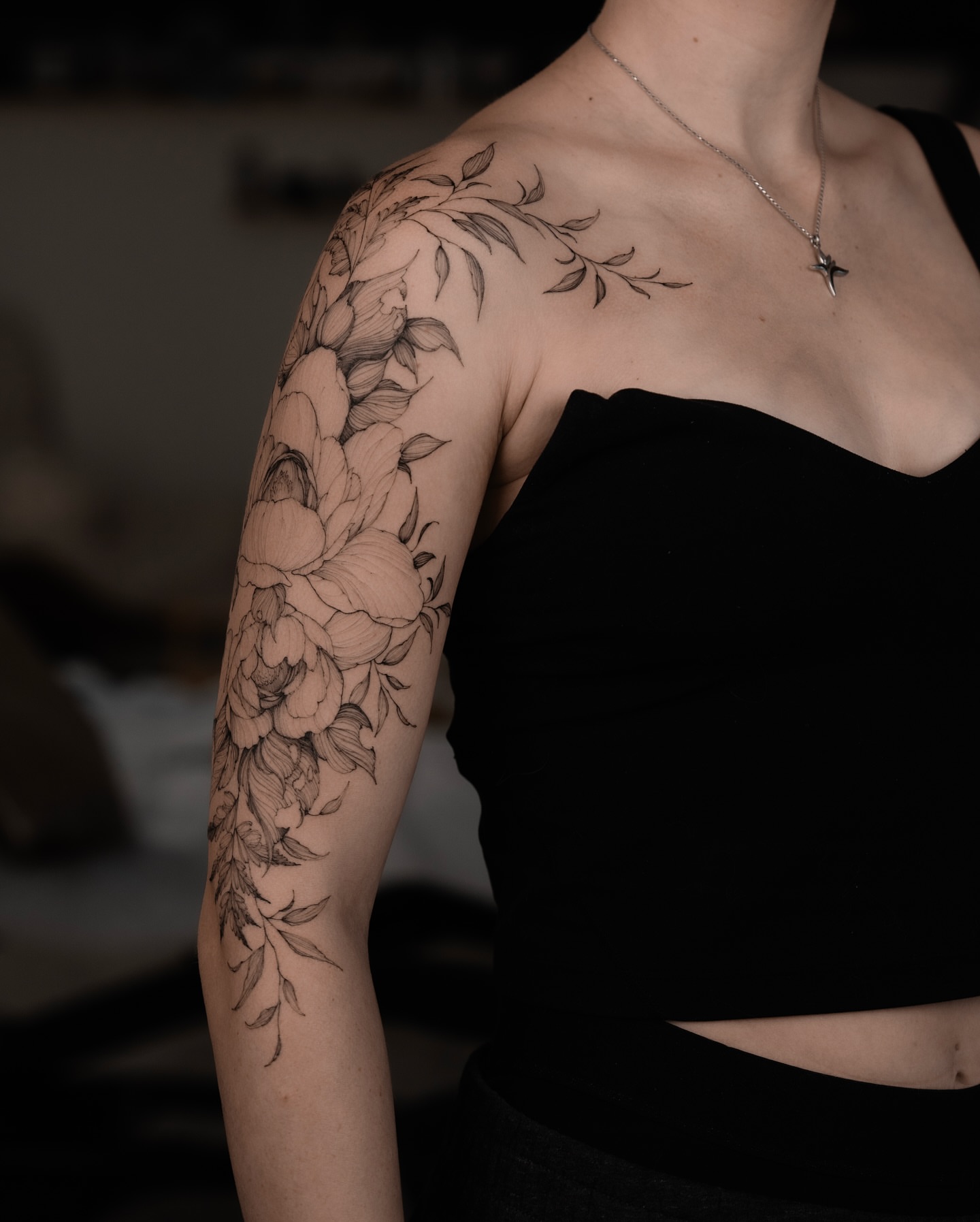 Floral bouquet black and grey tattoo on the upper arm by Marek