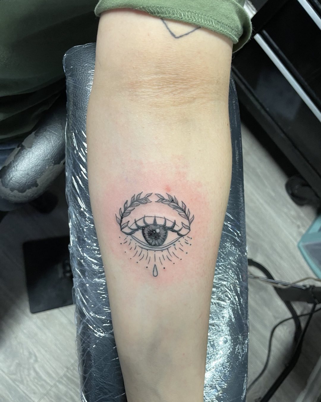 Eye with laurel wreath black and grey tattoo on the forearm by Vanessa - Dallas Artist