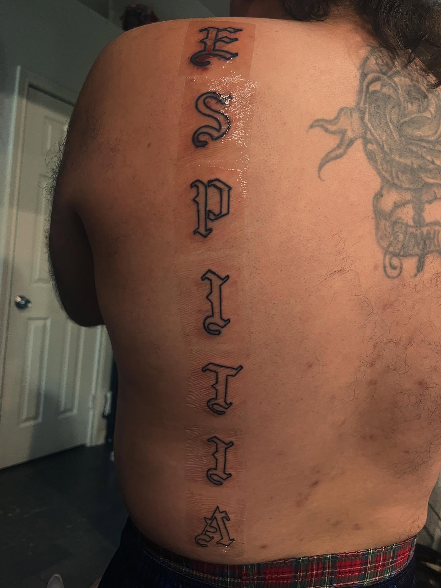Lettering lettering script tattoo on the back by Anna DeLuna