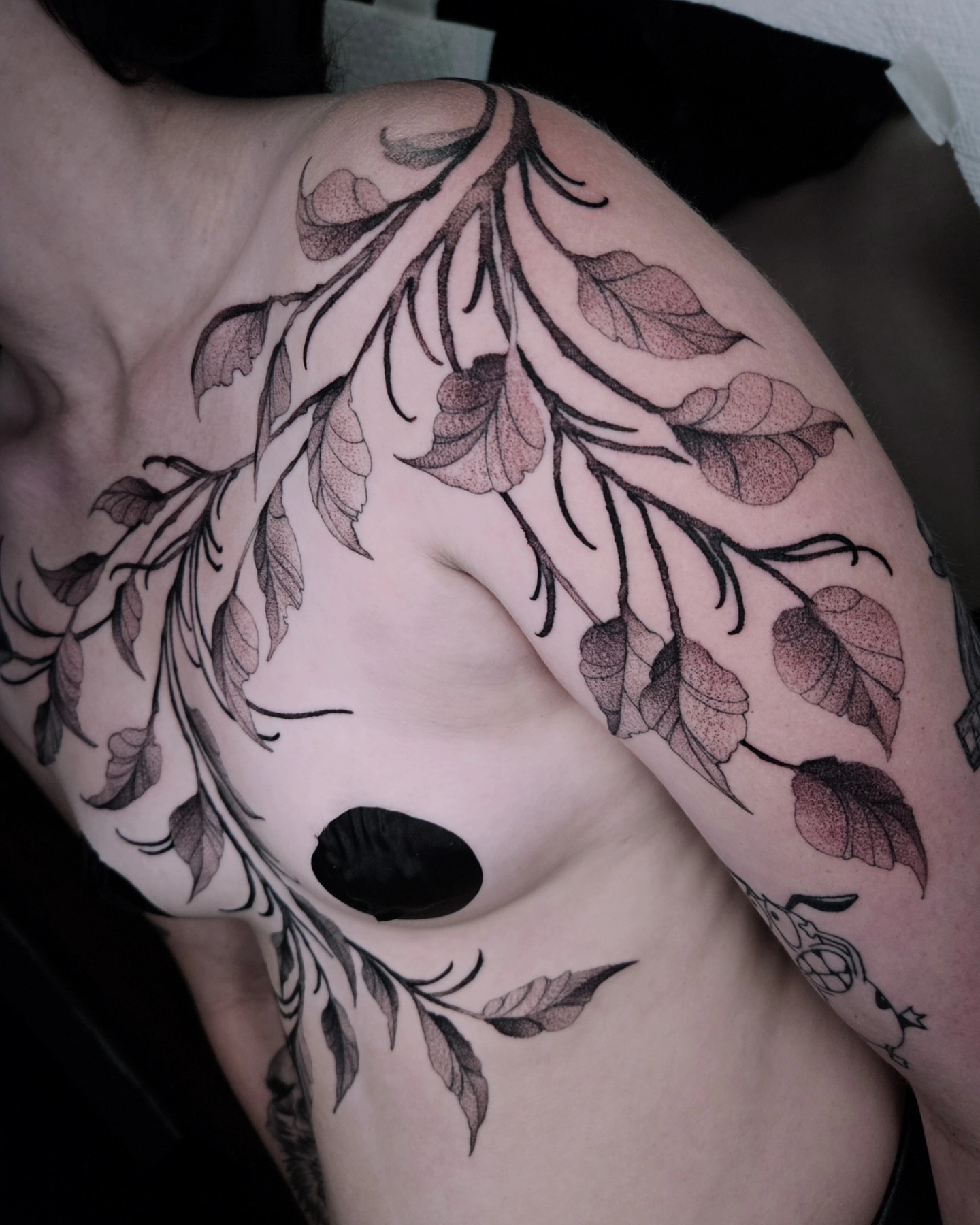 Branch with leaves dotwork tattoo on the shoulder by Sabrina Wagner
