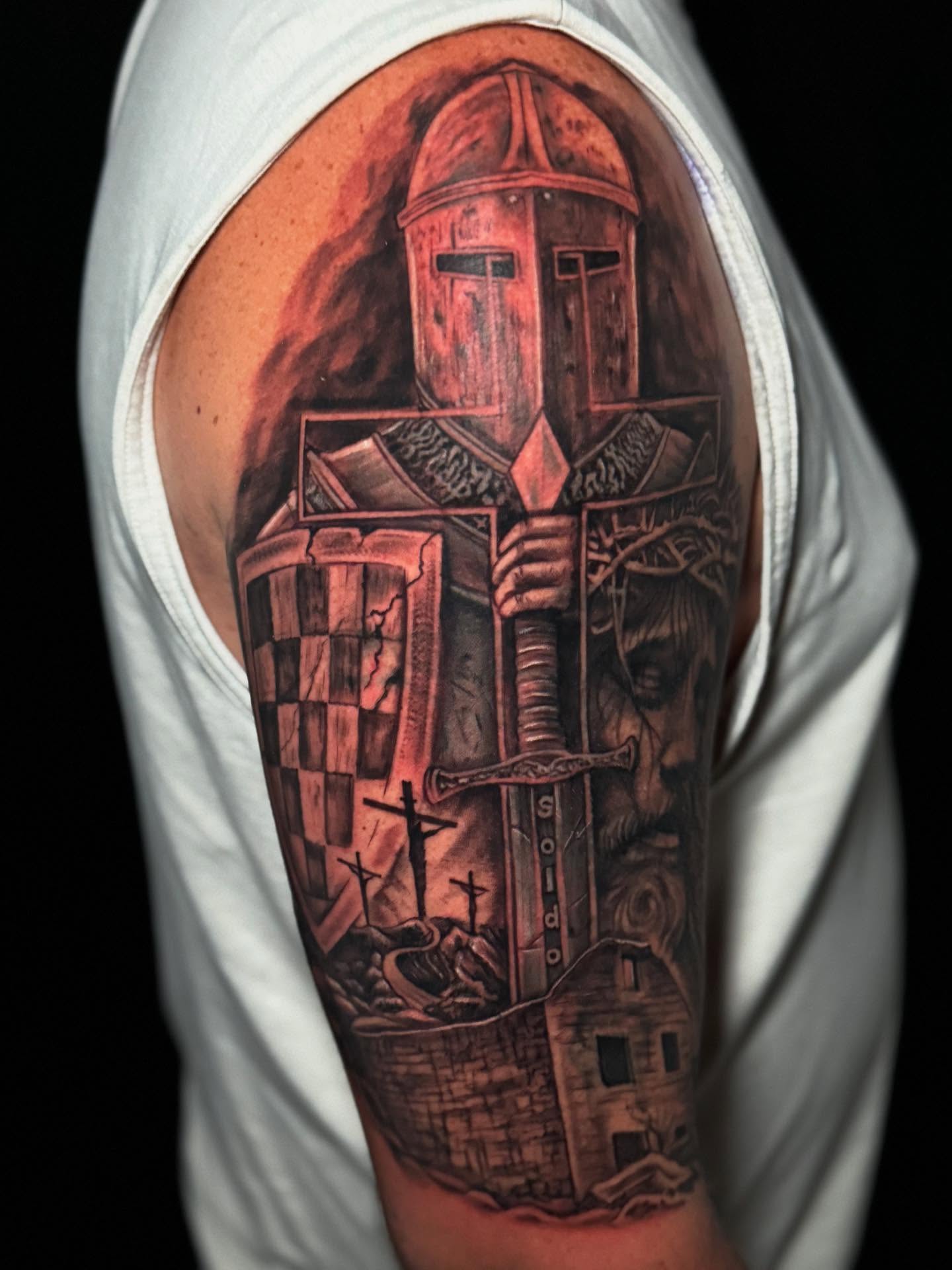 Knight with cross realism tattoo on the upper arm by Shawn Skale