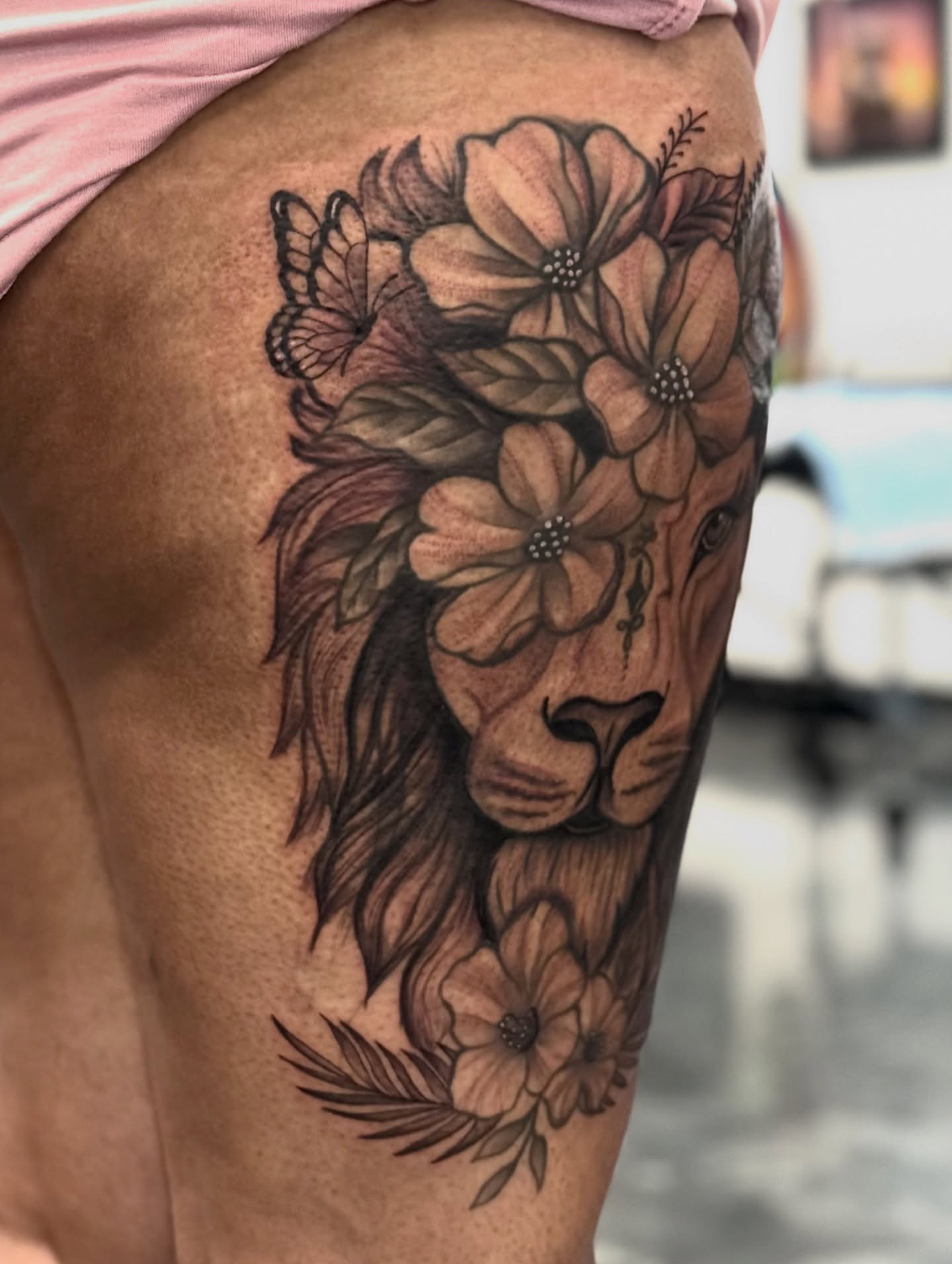 Lion with flowers realism tattoo on the thigh by Paola Pineda Tattoo, Knoxville, Tennessee